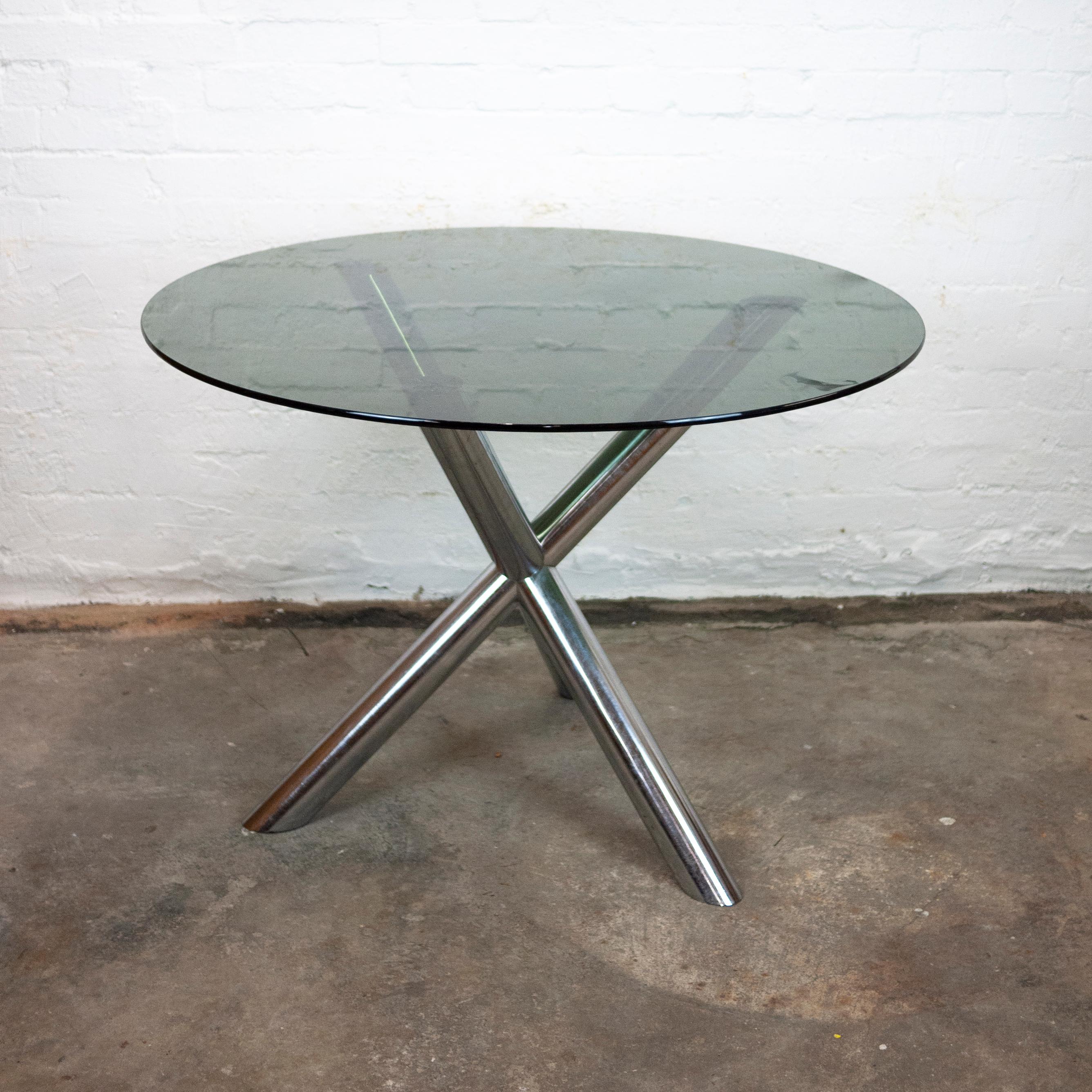 A round smoked glass top dining table with a chrome tripod base.

Designer - Renato Zevi

Manufacturer - Roche Bobois

Design Period - 1970 to 1979

Country of Manufacture - France

Style - Mid-Century

Detailed Condition - Good with