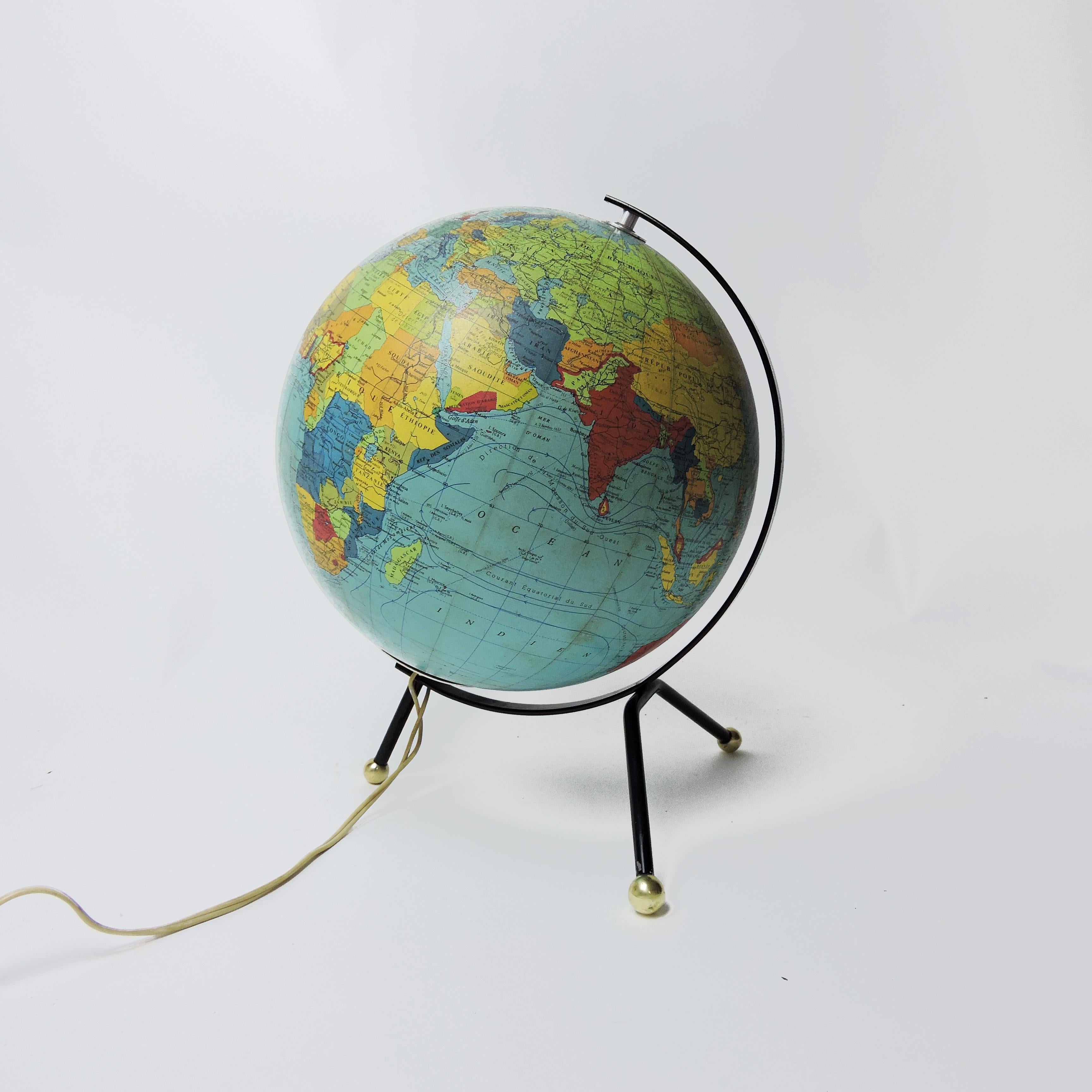 A 1966 luminous Cartes Taride globe with tripod base in black lacquered metal.