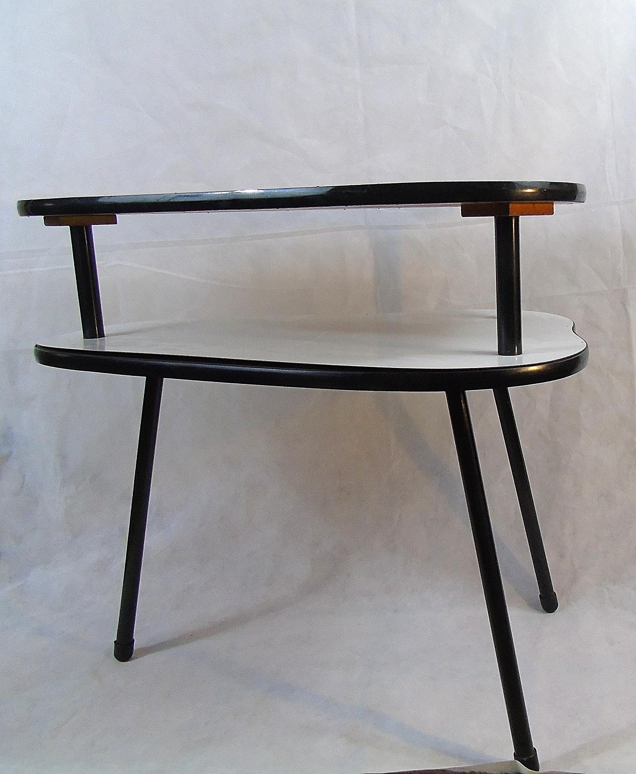 Small vintage two-tier side table or plant table made from formica.

This two-tone table looks charming and has a tripod base.

Good condition.

1960s, Belgium.

Diemensions: 
height 34.6 inches (75m)
width 27.5 inches (70cm).

 