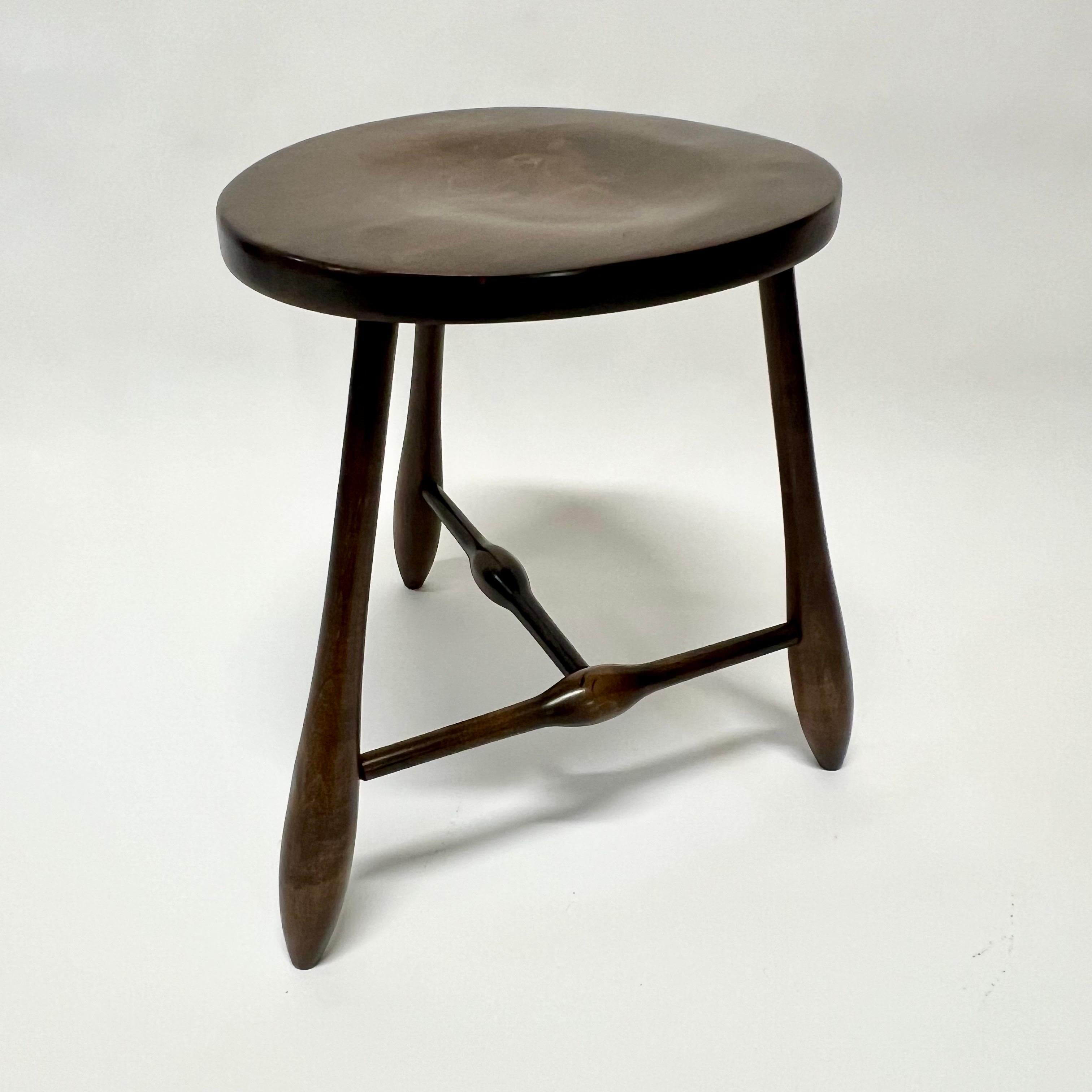 A tripod legged stool of solid walnut by the Hale Company of East Arlington, Vermont. Influenced by mid century Shaker furniture and stools by the master of American woodworkers, Wharton Esherick, of the 1950s. The club shaped legs are mortised and