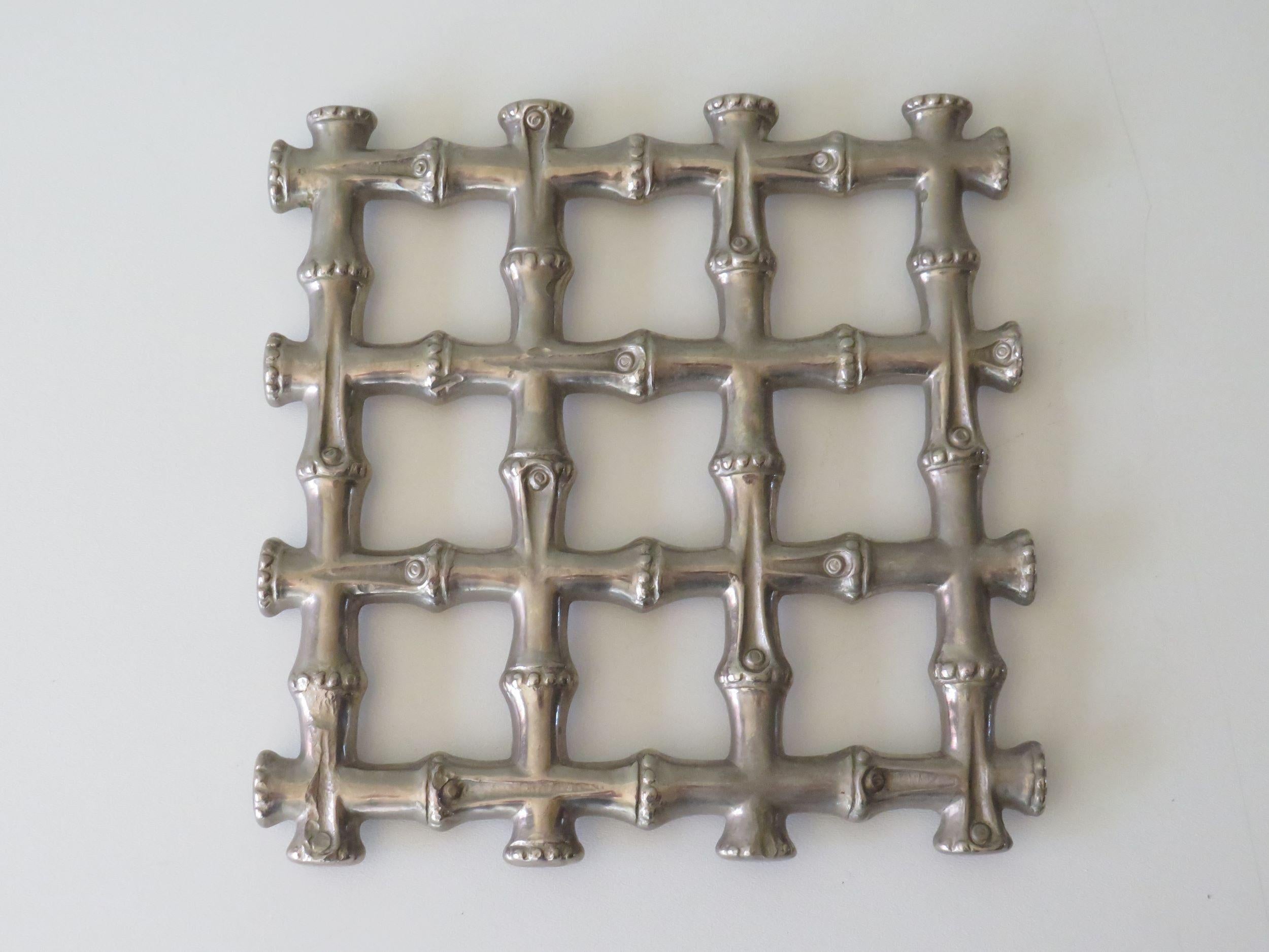 Square trivet, coaster in heavy metal, silver colored in Hollywood Regency style.