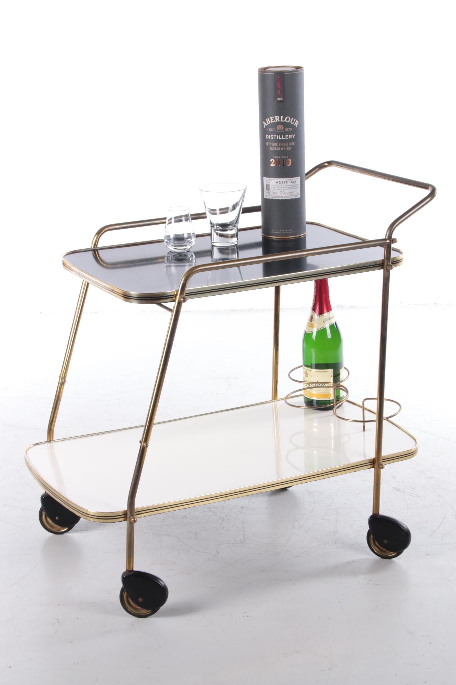Vintage Trolley tea cart or beautiful bar cart, 1960s


This is a beautiful trolley from the 1960s.

The lower tray is white and the upper tray is black. The frame is made of beautiful gold brass. On the lower floor there is also a nice rack to