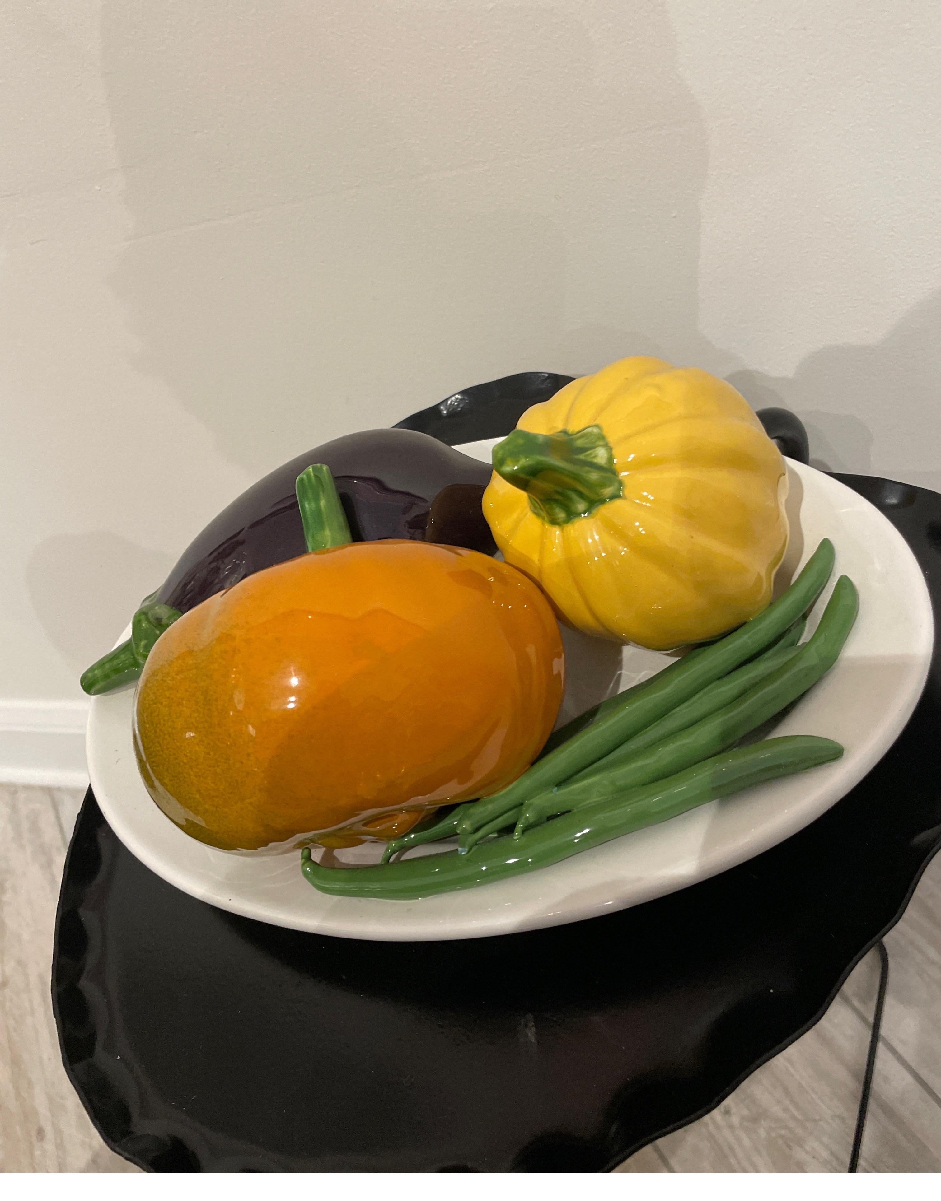 Plateau vintage ovale en trompe l'Oeil avec aubergines, courges et haricots verts sur fond blanc. Cette très belle pièce se suffit à elle-même et constituerait un excellent complément à votre collection.