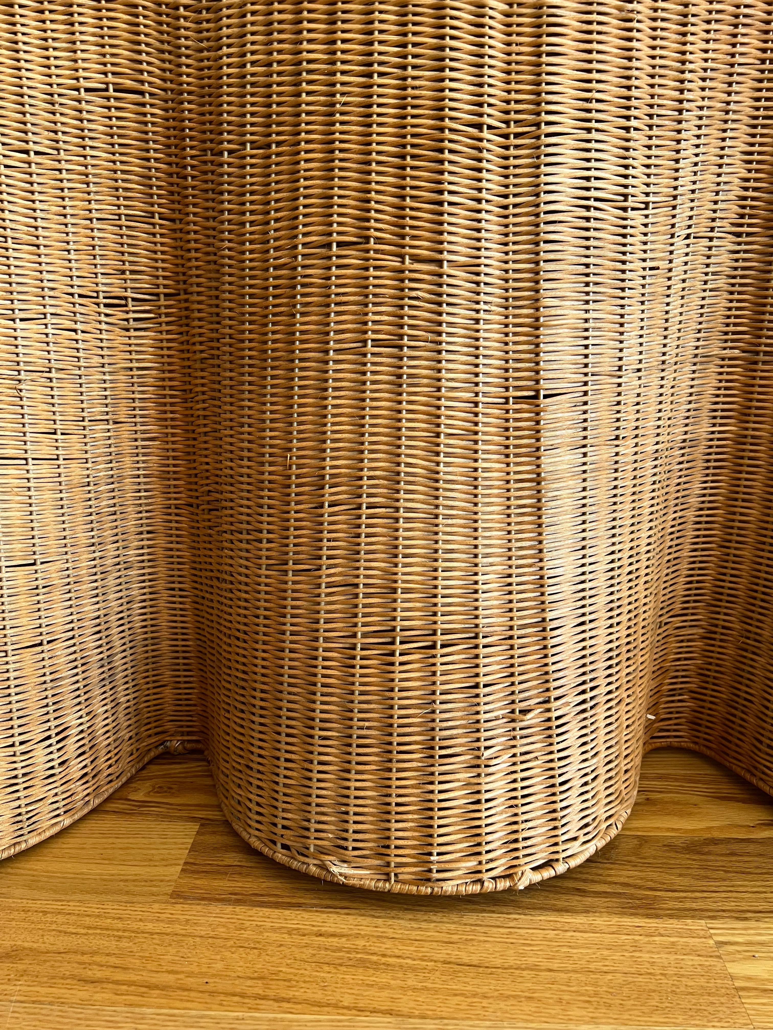 A vintage Trompe l’oeil wicker console table from the 1980s, designed to mimic the fluidity of draped fabric in meticulously handwoven rattan. The sculptural silhouette features an elegant cascading effect on both sides, creating a striking visual