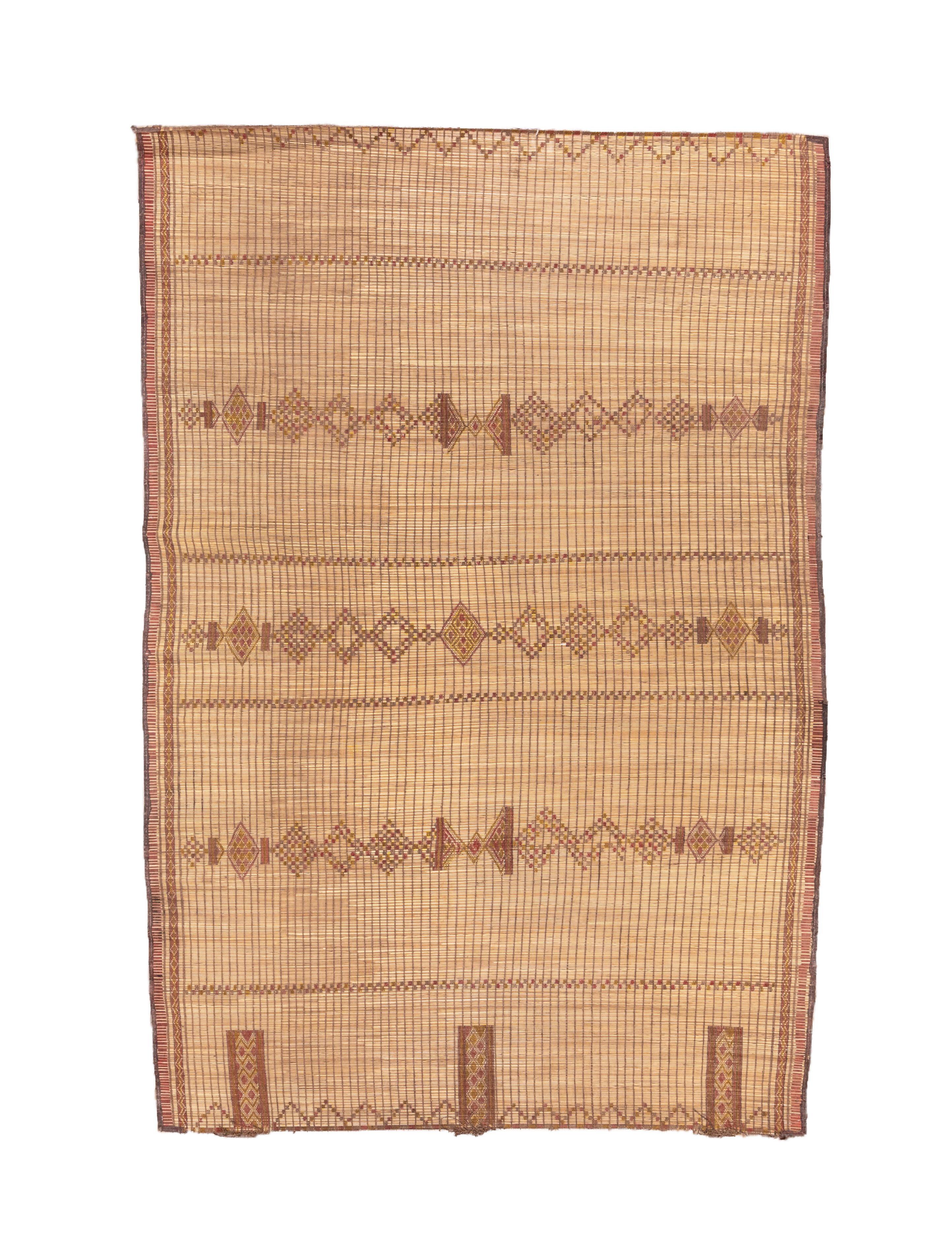 River reeds are bound together to create this attractive, tribal flatweave. Light tan reeds comprise the ground while three echelons of diamond chains in darker browns run across the centre. Rectangles stand at one end and zig-zags function as end