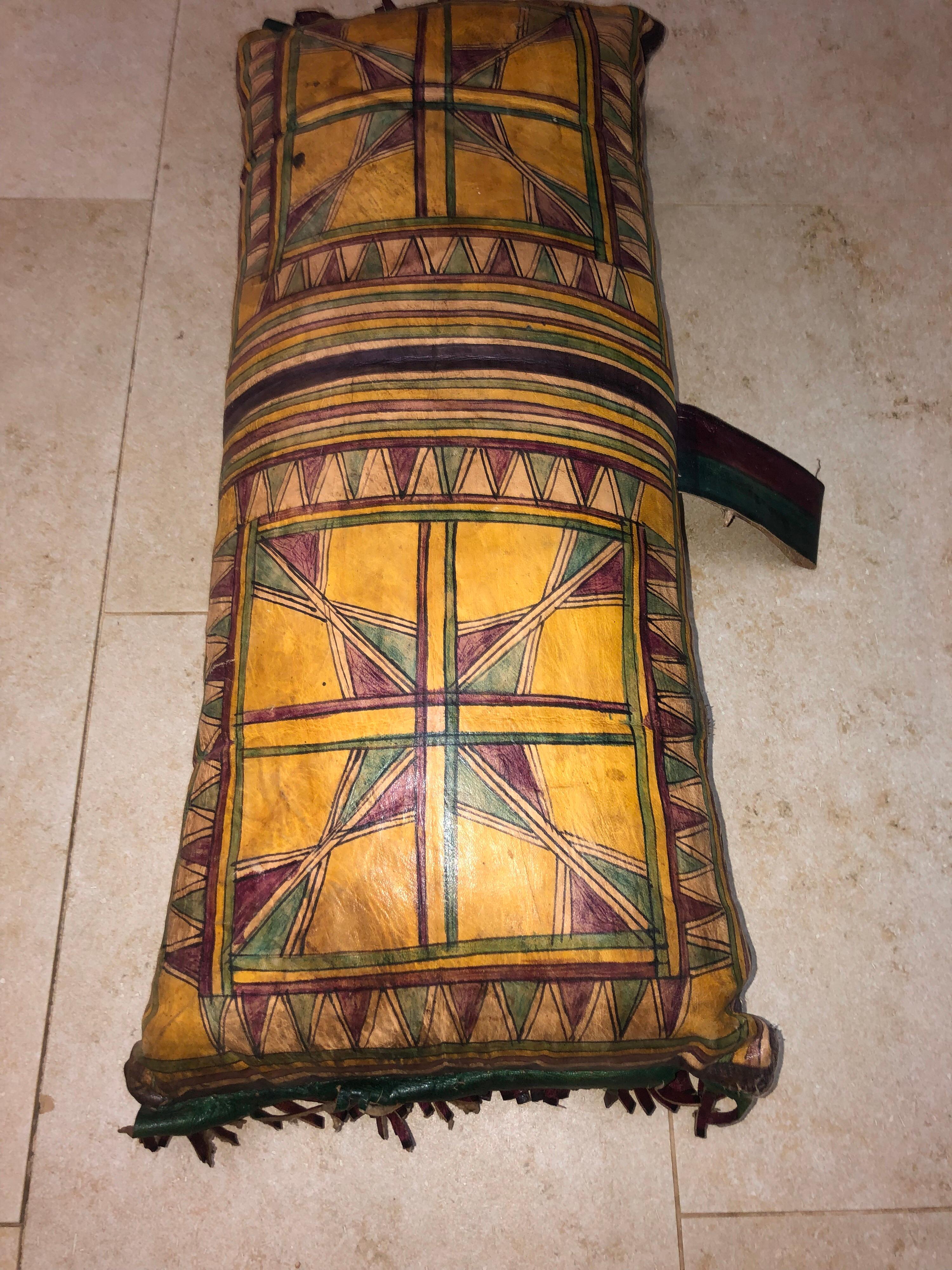 This vintage Tuareg camel saddle pillow is a stunning example of the abstract geometric art that is the hallmark of the Tuareg people. Hand-dyed using natural dyes and hand painted, this sturdy leather pillow is fully decorated on both sides with