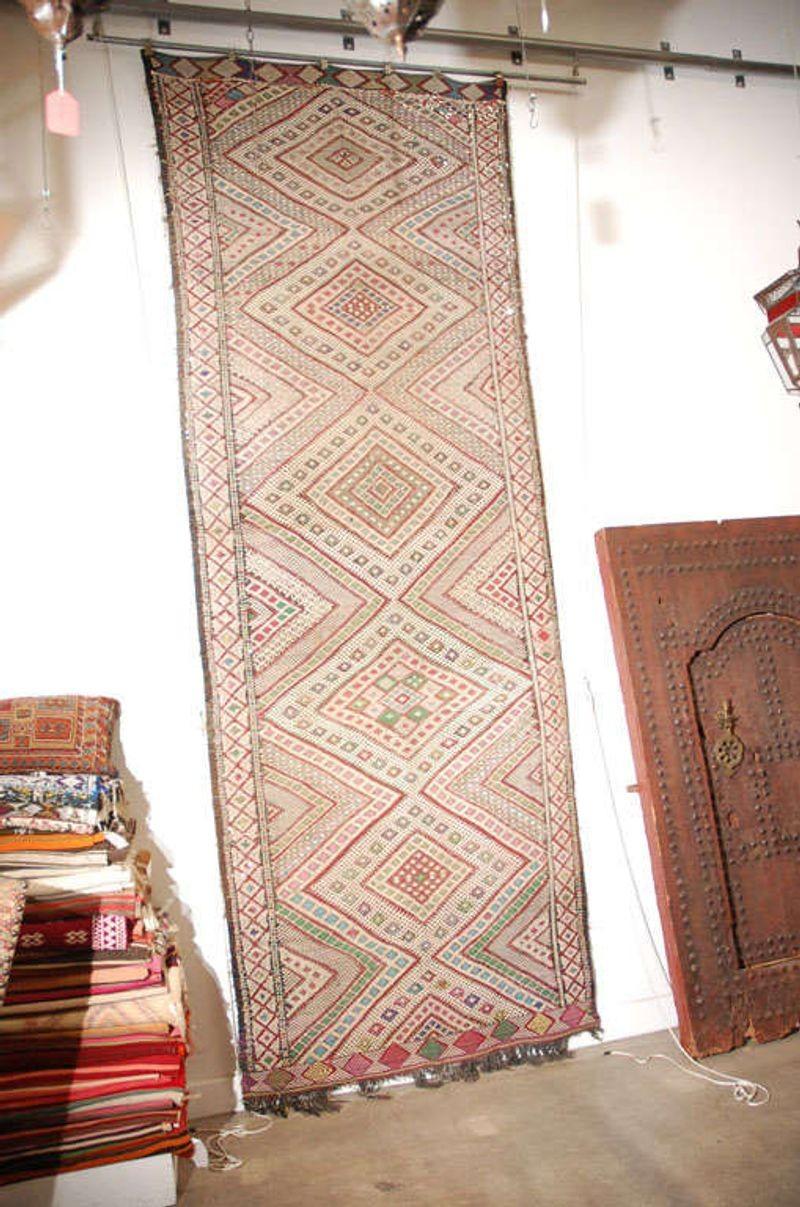 Vintage Tuareg Moroccan Tribal Runner Rug, circa 1960.Great handwoven vintage clector Moroccan Tuareg tribal runner rug.
Intricate geometric designs on flat-weave Tuareg rug, with some sequins.
Great faded cors.
Unique and beautif abstract work of