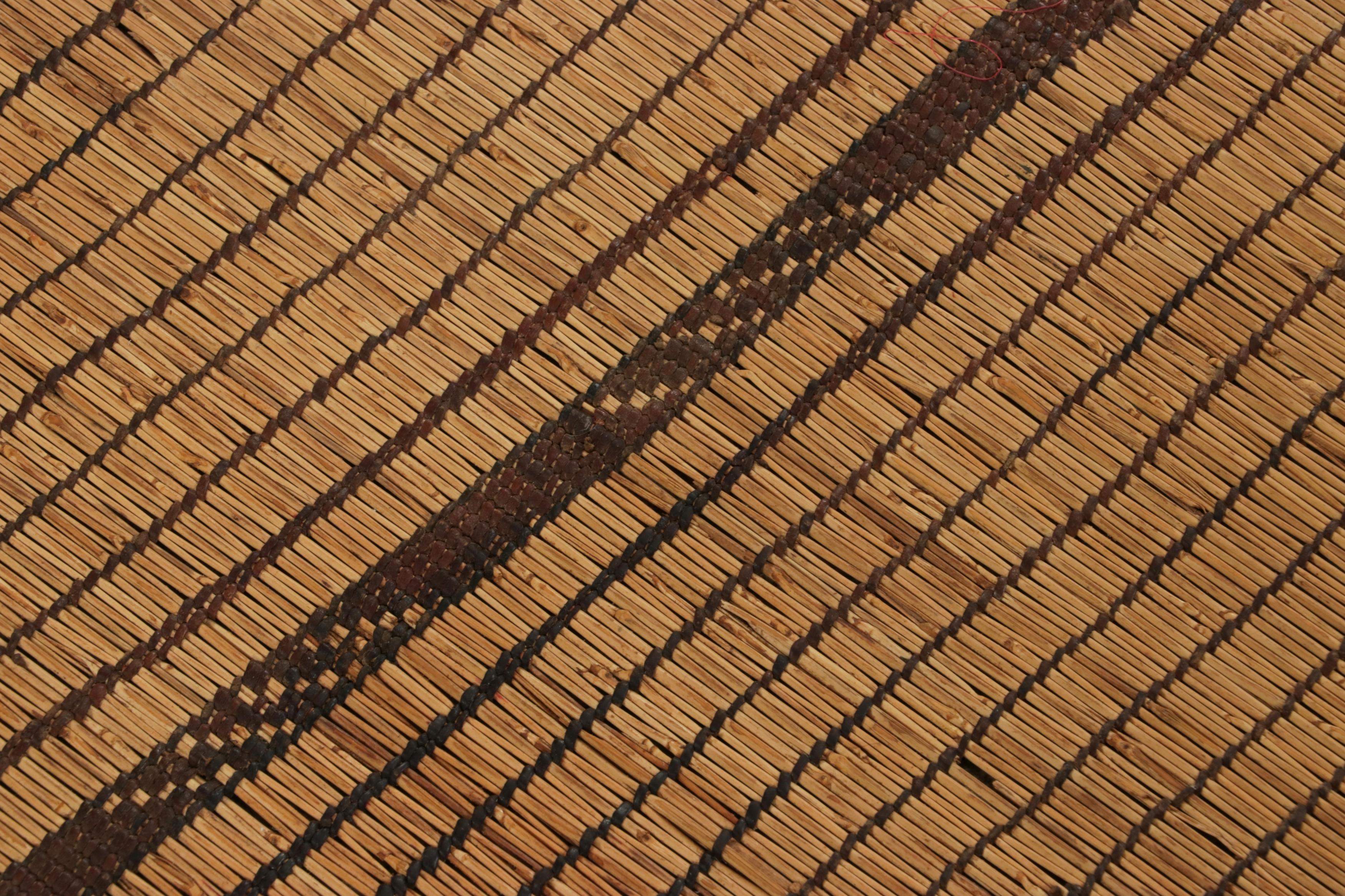 Dieser Vintage-Teppich und Bodenbelag ist eine 3x10 Tuareg-Läufermatte vom gleichnamigen Nomadenstamm. Er wurde um 1950-1960 in Mauretanien mit Schilf und Kamelleder handgewebt und ist eine aufregende neue Ergänzung unserer marokkanischen