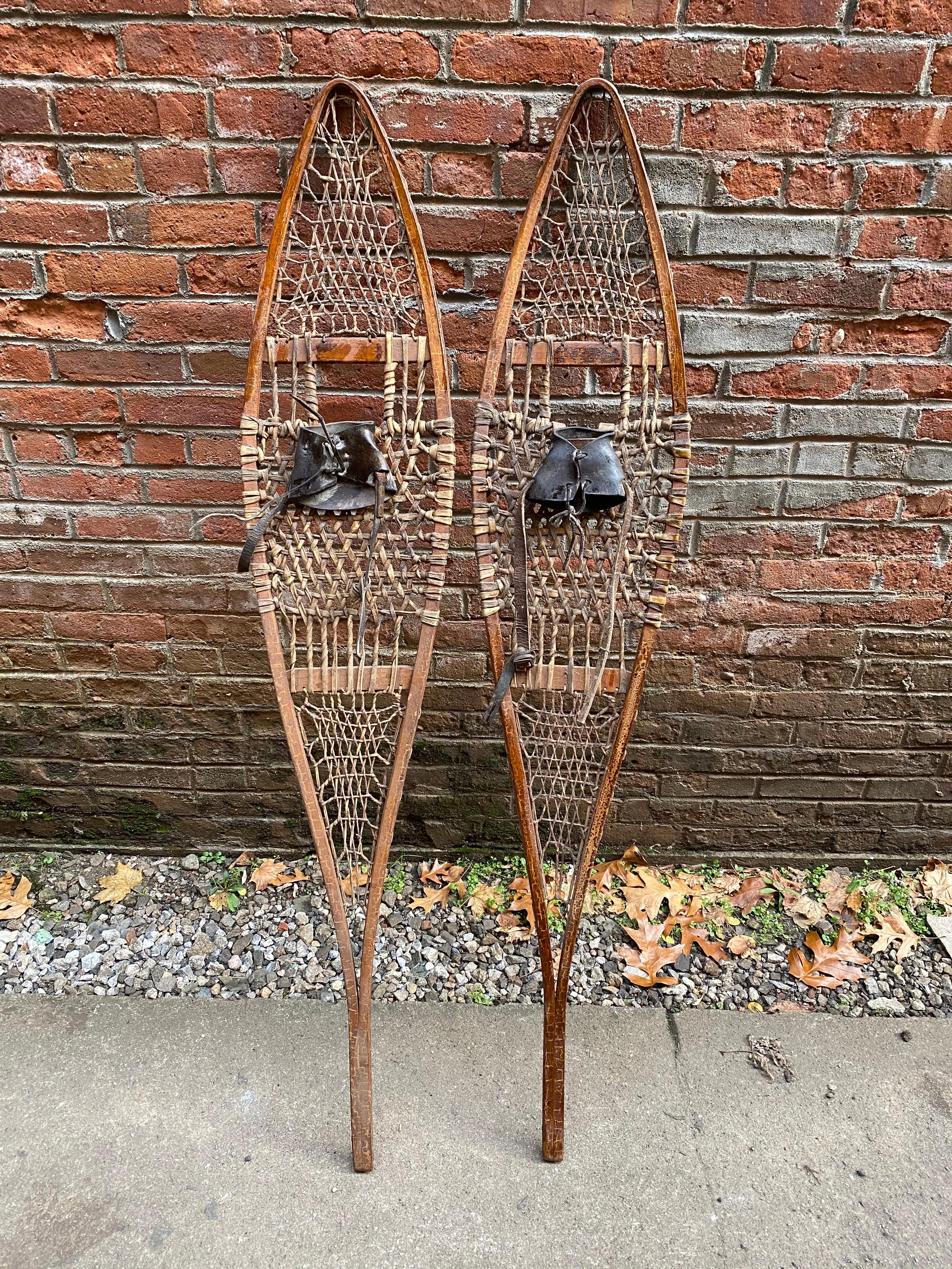 A beautiful pair of vintage Tubbs, Norway, Maine ash and rawhide snow shoes. Weathered, worn and used, they bare the right patina and wear as an excellent wall mounting or conversation piece. One shoe still retains a partial transfer decal: The