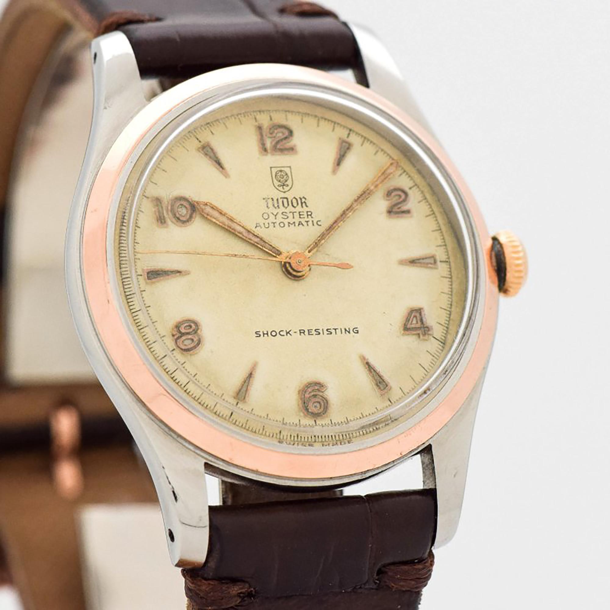 1964 Vintage Tudor by Rolex Oyster Two Tone 14k Rose Gold Bezel and Stainless Steel watch with Original Patina Dial with Applied Framed Luminous Arabic Even Numbers and Elongated Arrow Markers. 34mm x 41mm lug to lug (1.34 in. x 1.61 in.) - Powered