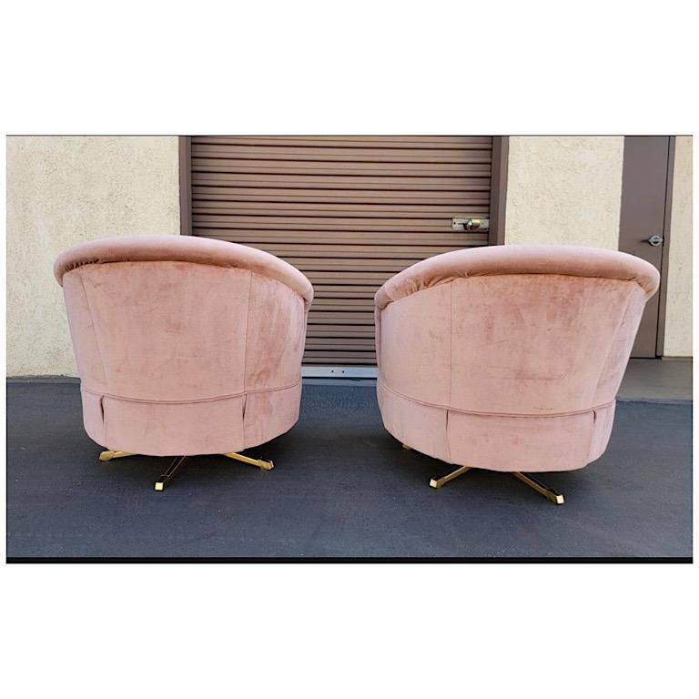 This matching vintage set of pink velvet club chairs feature a trendy barrel design and tufted backs. These vintage chairs have been modernized by altering the skirts to showcase the updated gold atomic bases, while still maintaining the original
