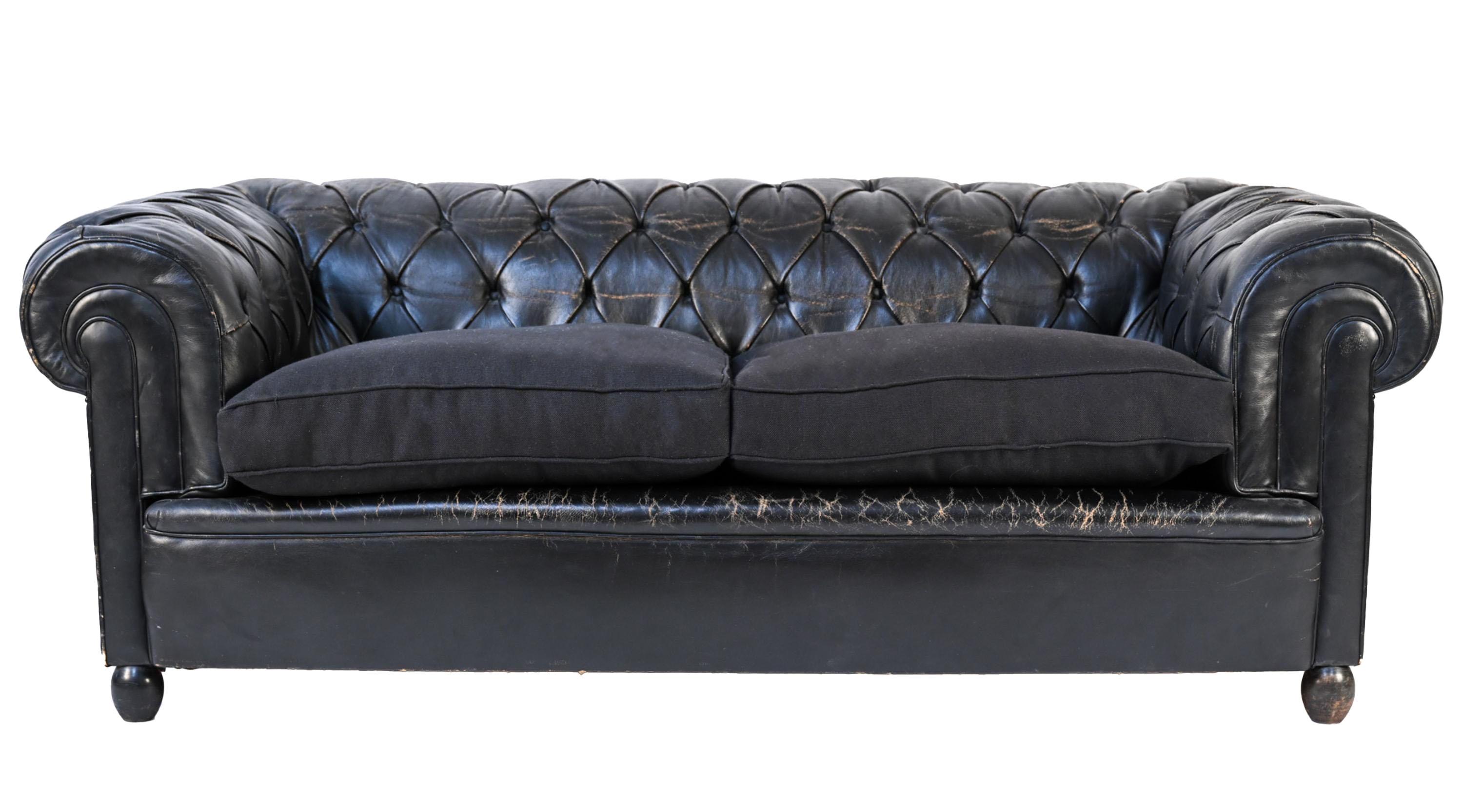 A pair of fabulous vintage black leather tufted Chesterfield sofas. The leather is in good condition with just the right amount of patina and wear. The sofas are made with jute webbing and are down feather filled and upholstered in black velvet. it