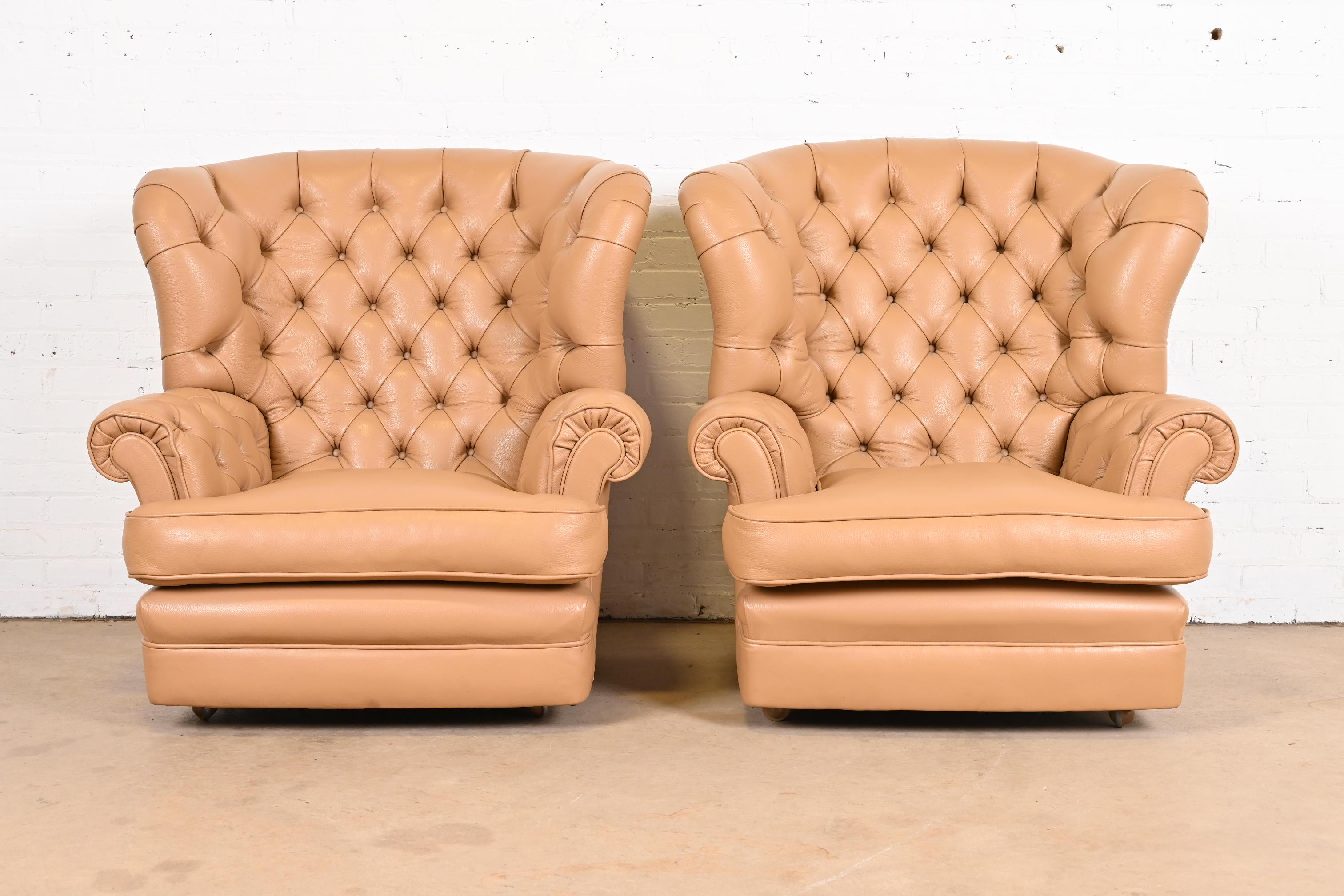 A gorgeous pair of Chesterfield style wingback fireside chairs, club chairs, or lounge chairs

USA, Late 20th Century

Tufted leather, on rolling castors.

Measures: 38