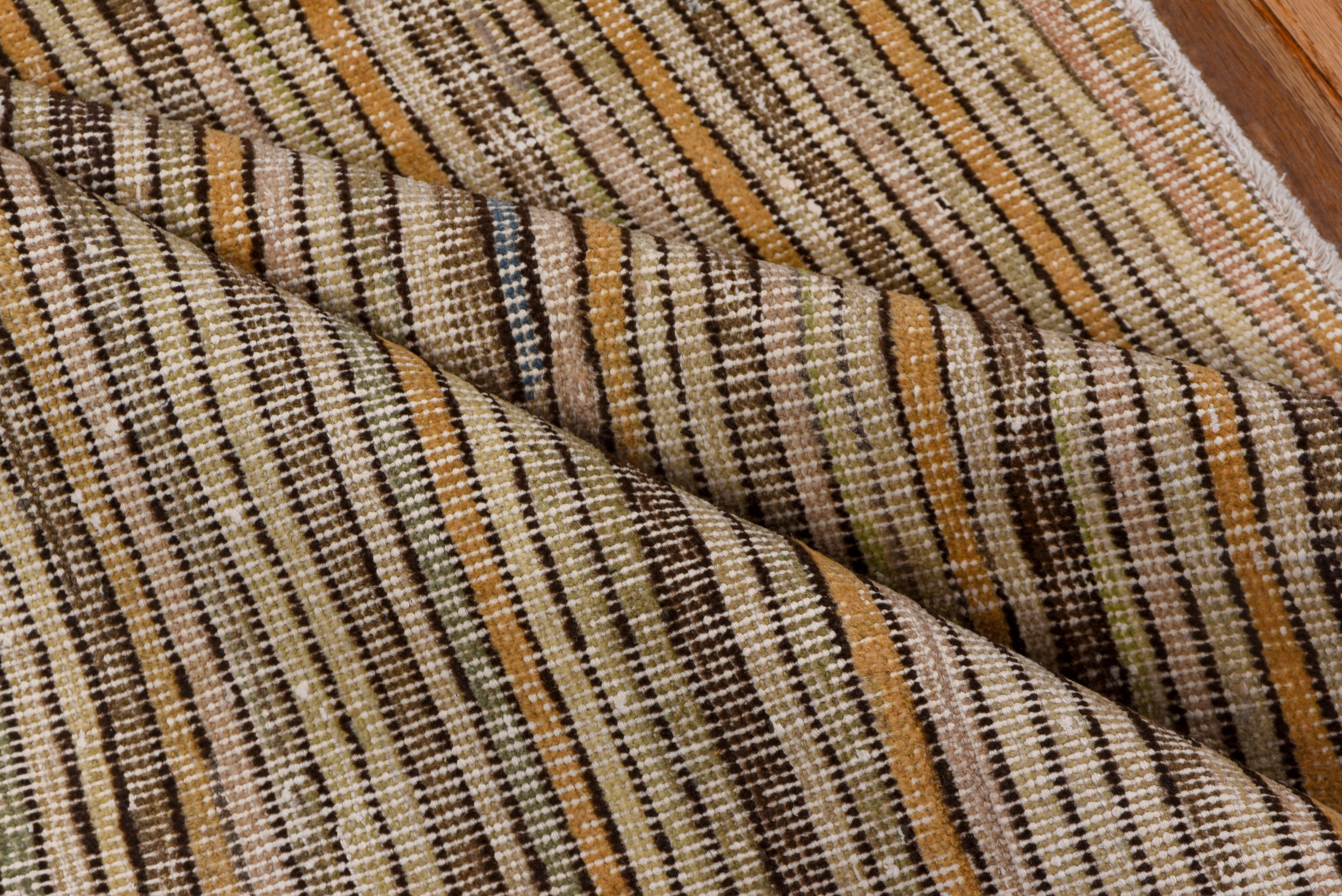 This vintage Tulu rug showcases a beautifully organic linear stripe pattern in warm, earthy tones of beige, chestnut, sand, and olive. The irregular handwoven lines create a sense of quiet movement and texture, celebrating the simplicity and tactile