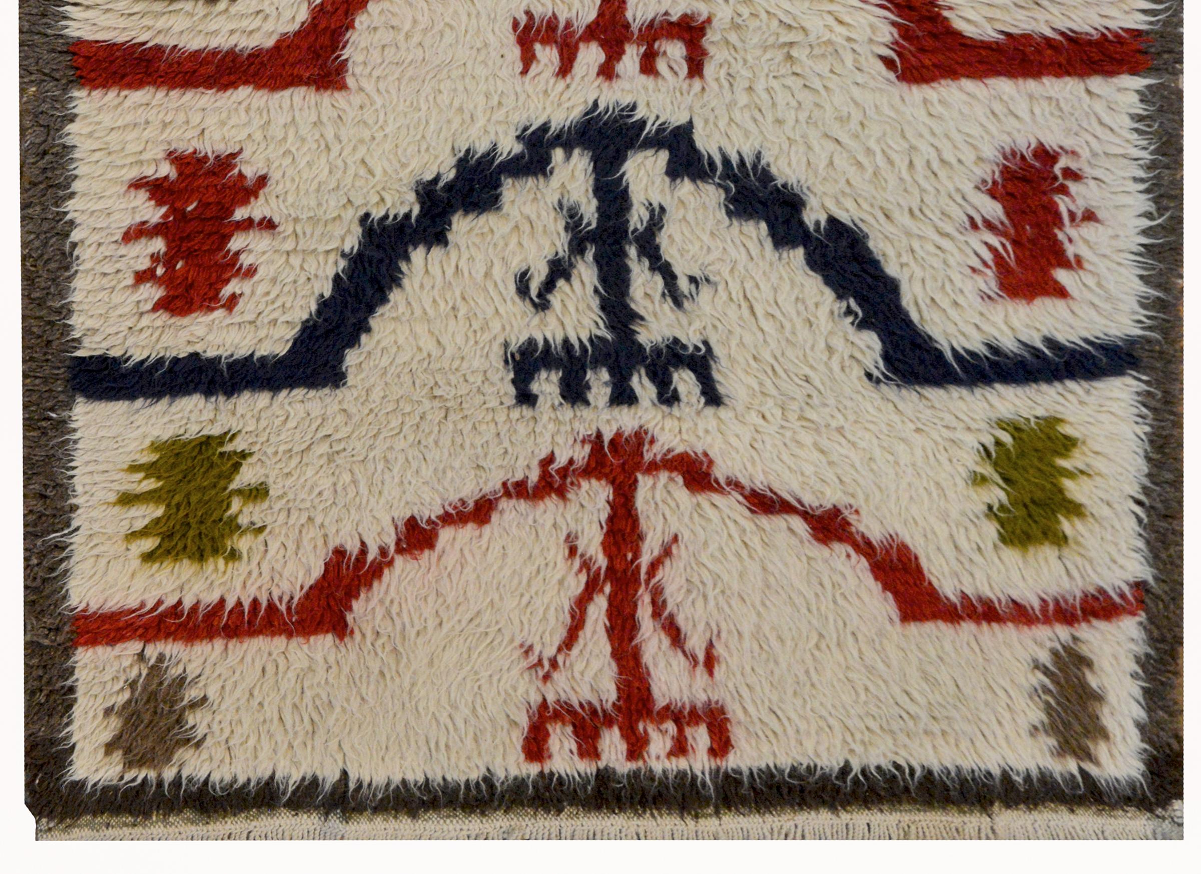 A wonderful vintage Turkish Tulu rug woven with shaggy Angora wool with a tribal pattern containing several crimson and indigo arched stripes, and stylized green and red flowers.