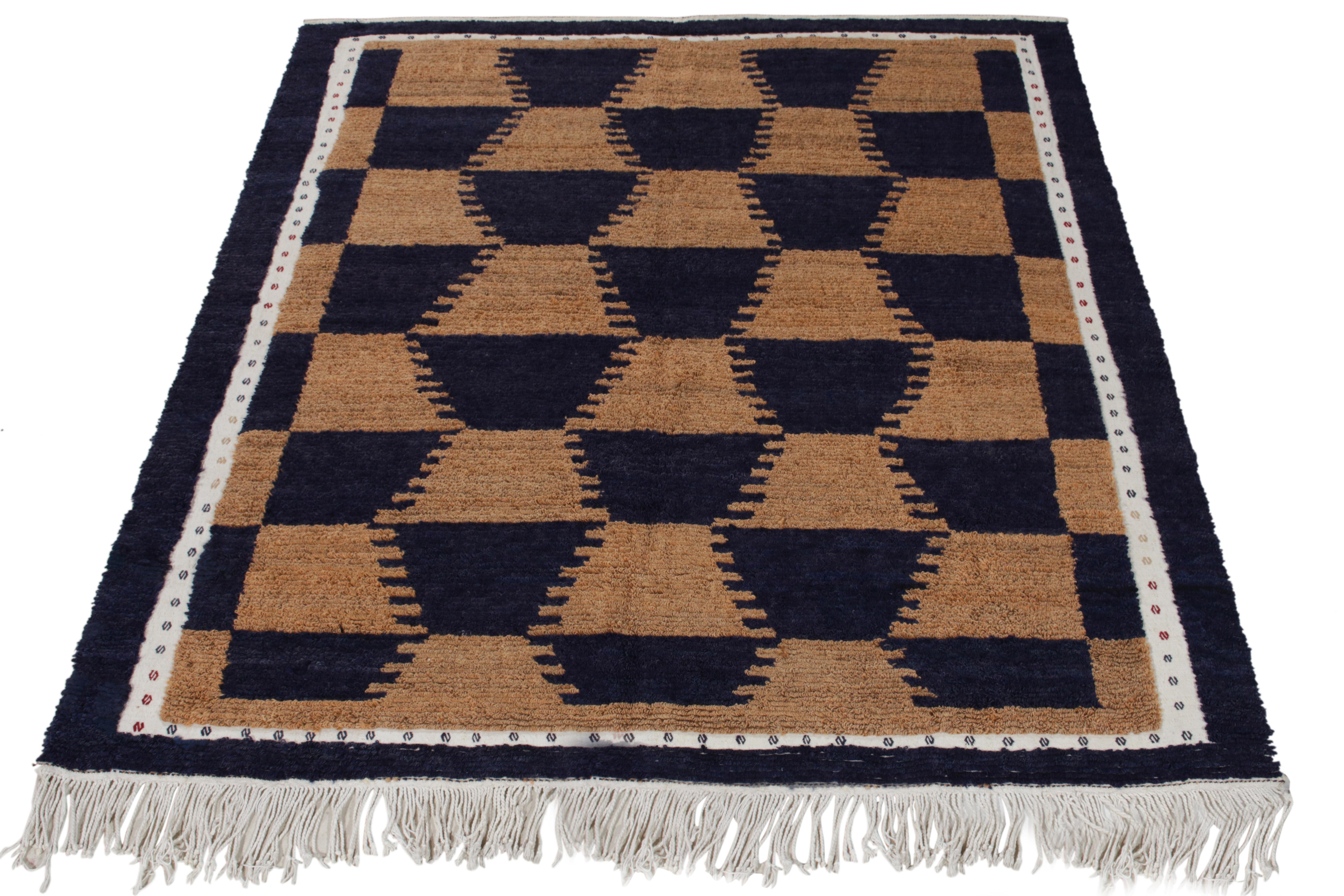 A specimen of artistic acumen, this Tulu rug of the 1950s from our Antique & Vintage collection unveils sharp geometry in tribal designs bracing light brown & grisailles blue tones. Connoisseurs may observe a delicate white border carrying tribal