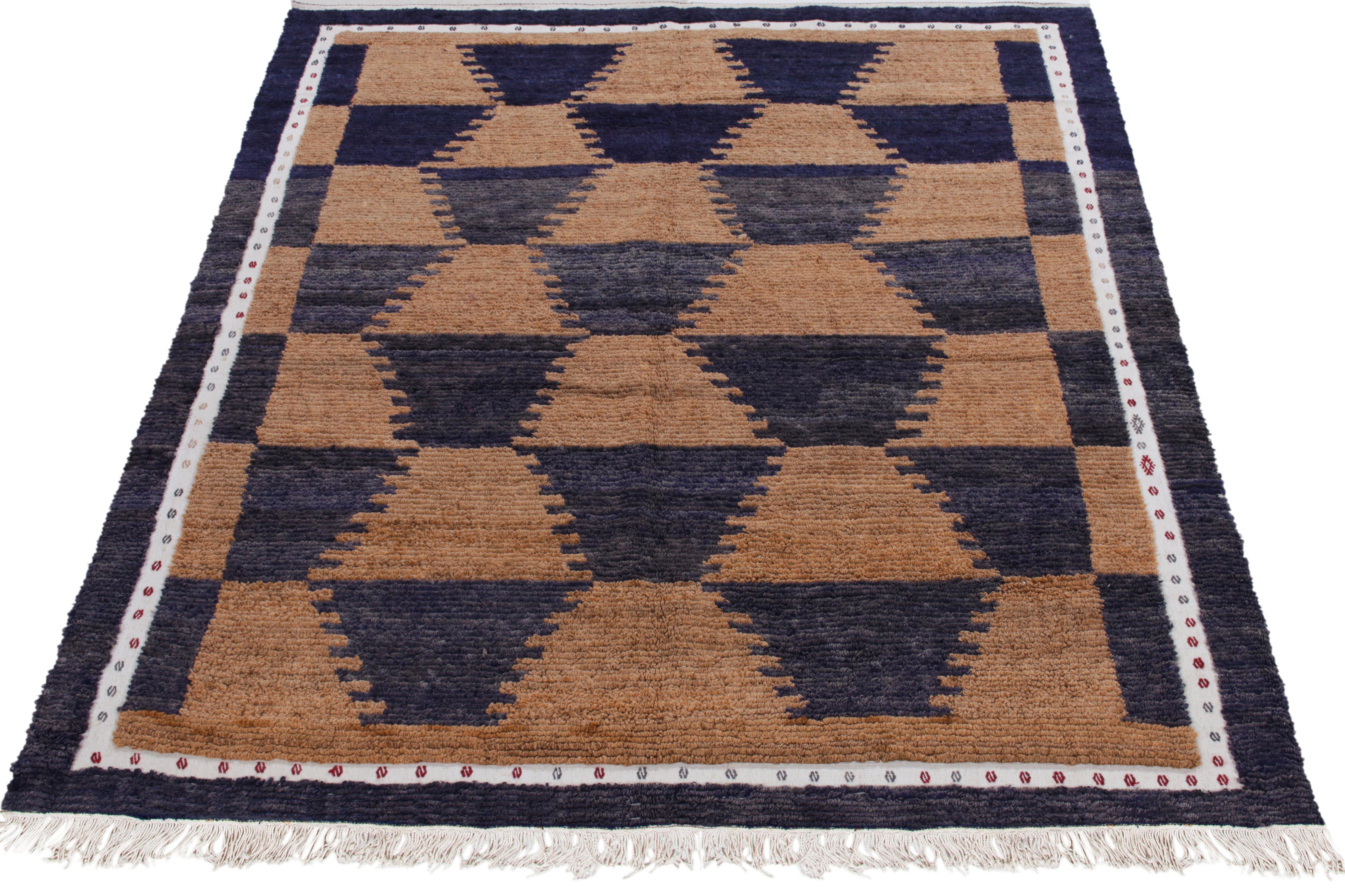 A specimen of artistic acumen, this vintage 6x7 Tulu rug of the 1950s from our Antique & Vintage collection unveils sharp geometry in tribal designs bracing light brown & lustrous midnight blue tones. Connoisseurs may observe a delicate white border