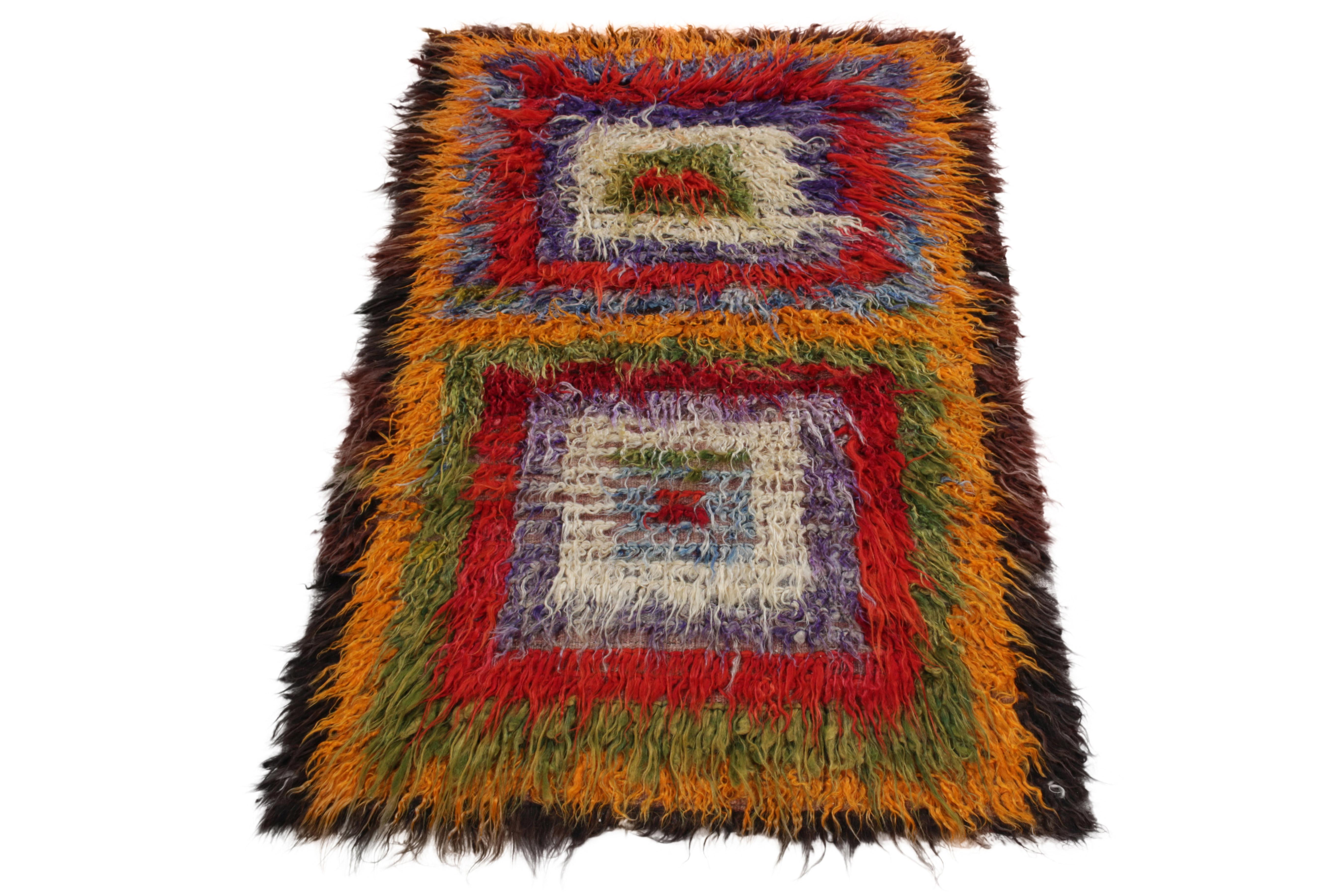Coming from Turkey circa 1950-1960, this 4x7 vintage shag rug enjoys a resplendent high pile in ink blue, bright red, white, tangerine & pista green complementing geometric sensibilities of Tulu lineage in high-low texturability of the mid century