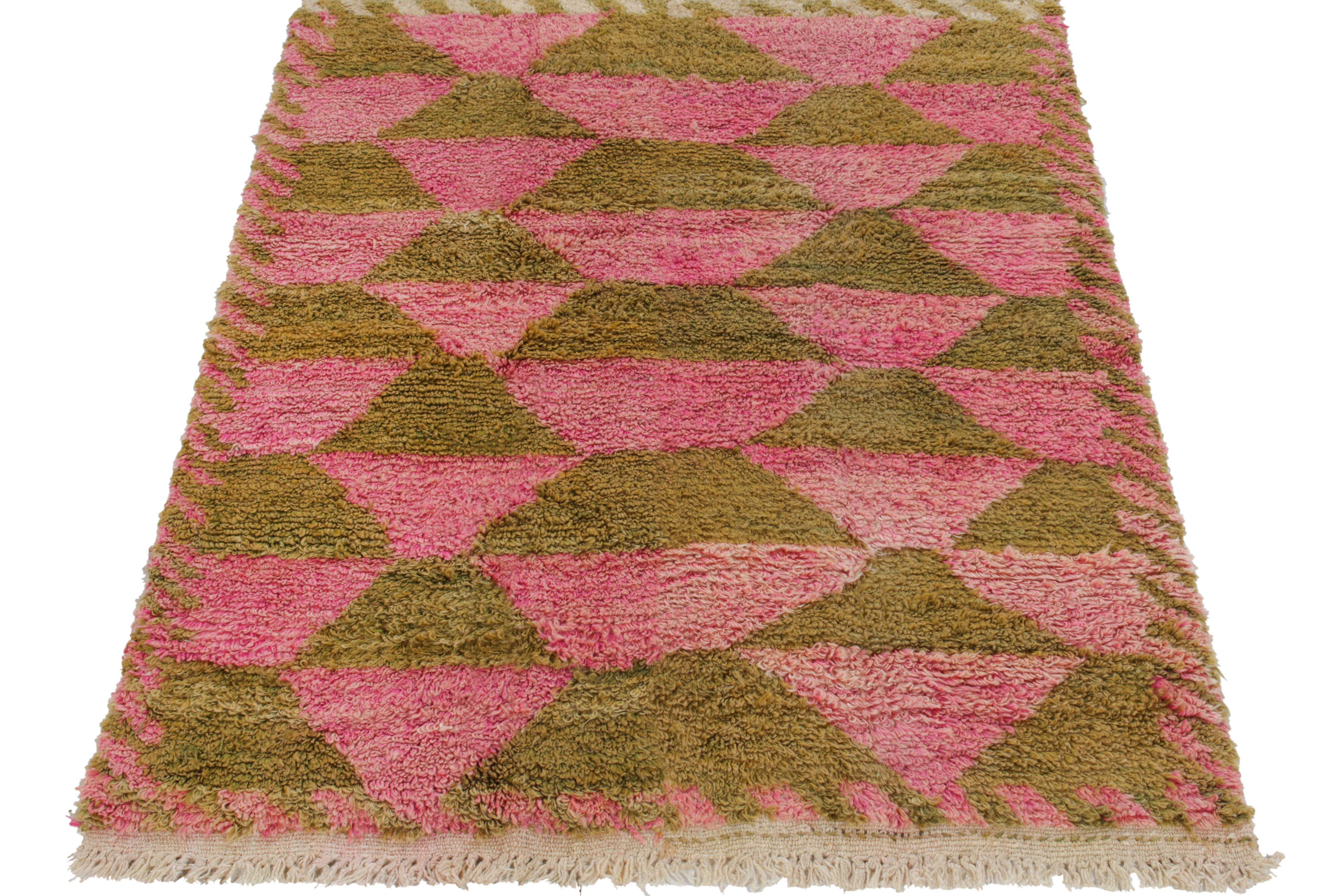 Hand-knotted in wool from Turkey circa 1950-1960, a 4x5 vintage rug from our Antique & Vintage collection connoting the classic Tulu style with a repetitive tribal geometric pattern in henna green & candy floss pink engulfed in an irregular border