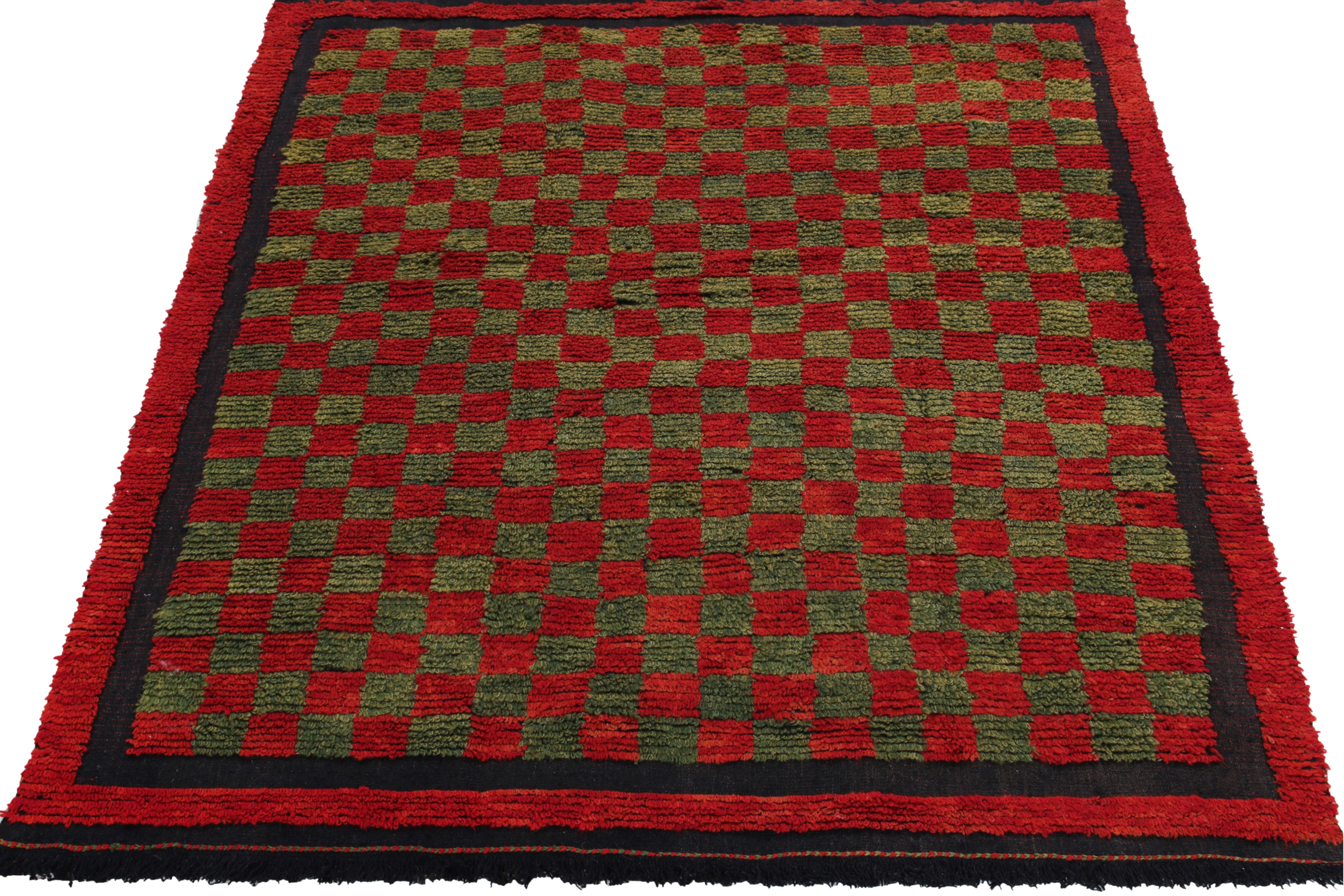 Originating from Turkey circa 1950-1960, this 4x6 vintage Tulu rug enjoys a bright red checkered pattern sitting boldly on luscious olive green for a delicious contrast all enveloped in similar red & navy blue tones. Hand-knotted in wool, the