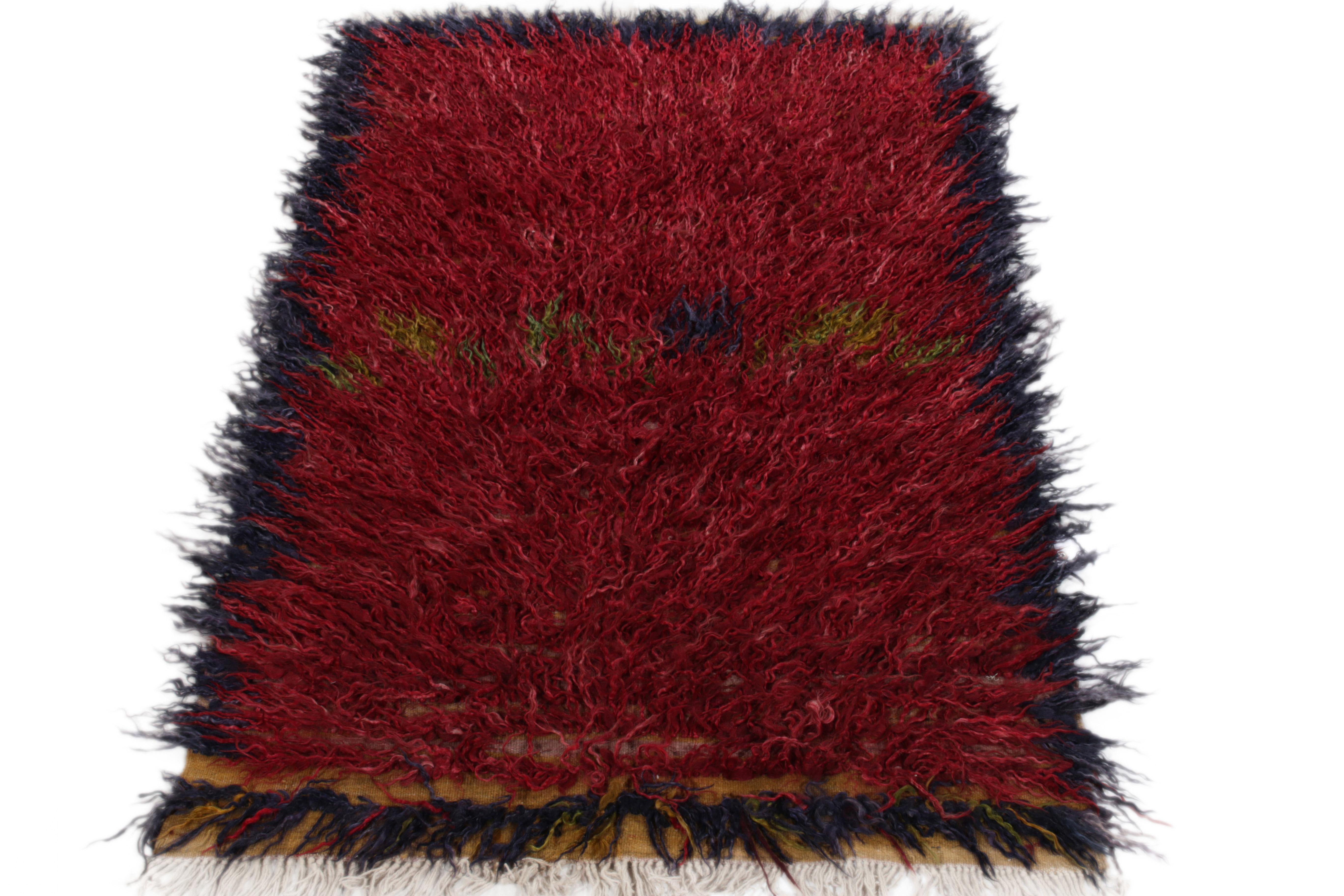 Hand-knotted in wool, this 4X7 Tulu rug from Turkey circa 1950-1960 joins Rug & Kilim’s Antique & Vintage collection in its coveted textural allure. Featuring a healthy high pile, the rug enjoys a bold colorway of richred, with a navy blue border,