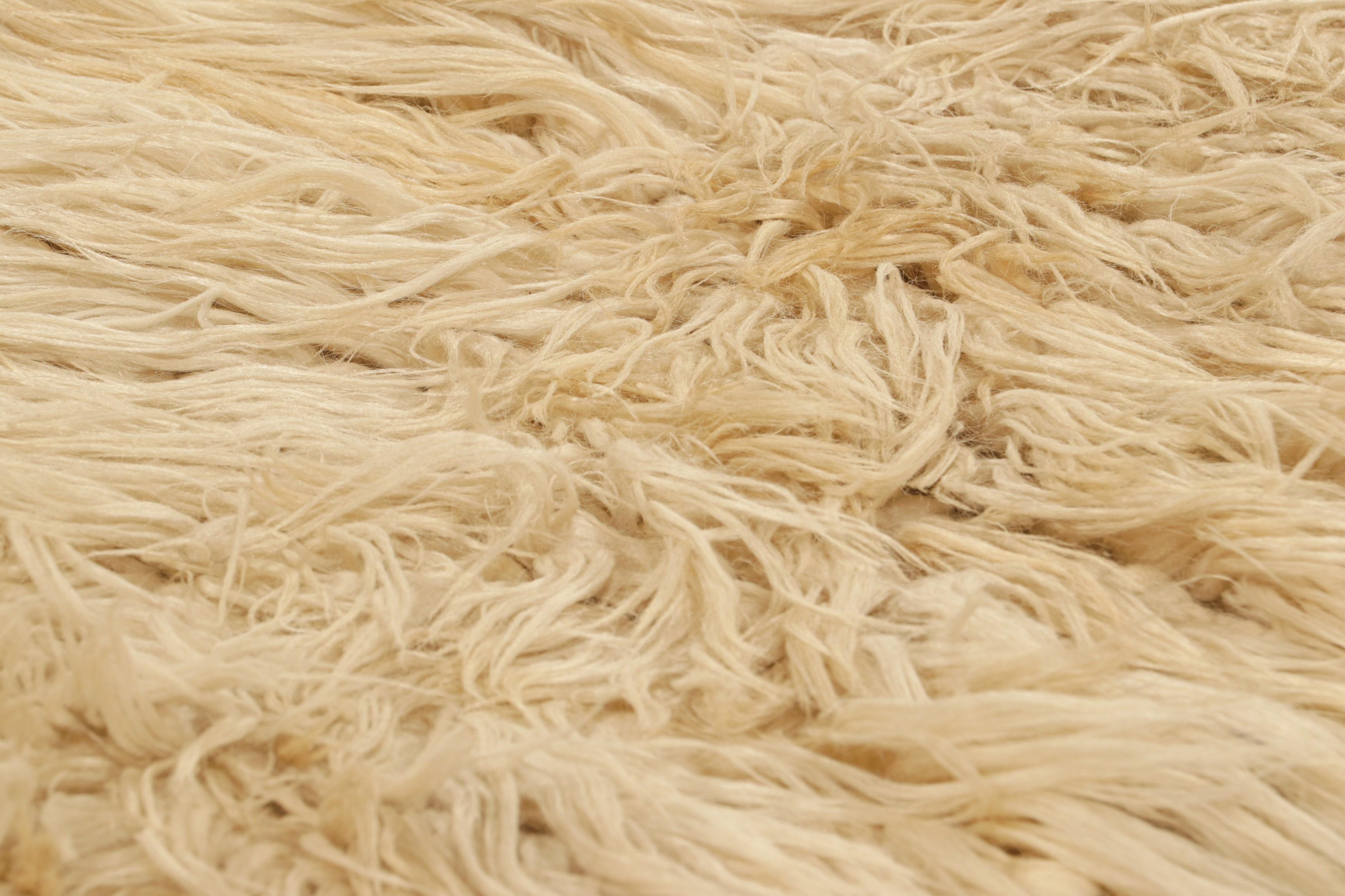 Originario della Turchia, intorno al 1950-1960, questo tappeto shag runner vintage 3x8 è caratterizzato da uno splendido vello alto nei toni del beige e del crema, che integra la sensibilità geometrica del lignaggio Tulu nel design testuale