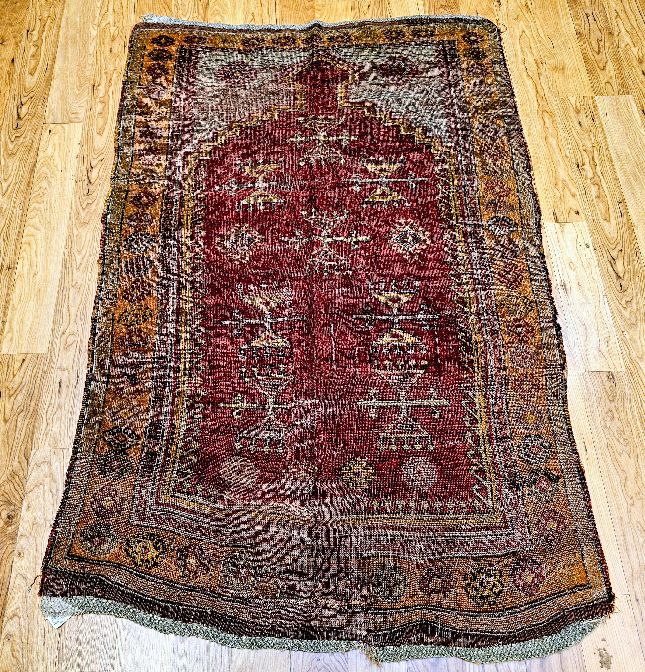 Dieser exquisite türkisch-anatolische Teppich zeigt ein traditionelles Gebetsteppichmuster, das in den frühen 1900er Jahren von Dorfhandwerkern handgewebt wurde. Das zarte, blassrote Feld wird durch graue, cremefarbene, orangefarbene und zartrote
