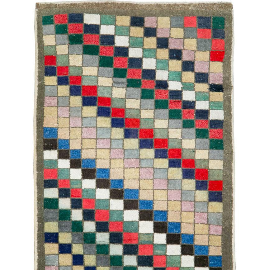 A vintage Turkish Anatolian Deco runner. Only a string border encloses the ultra-colorful diagonal stripe pattern in which each stripe is composed of small linked squares. Red, goldenrod, camel, ecru, cerulean blue, navy, green and dark brown are