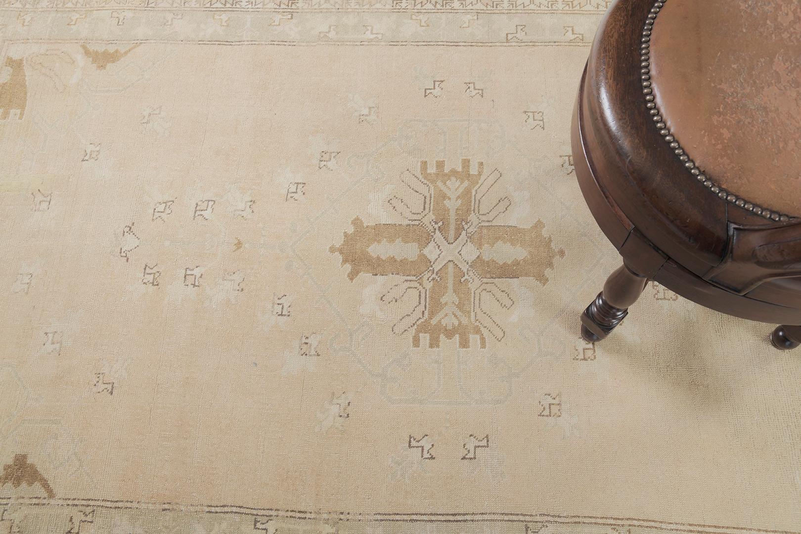 This graceful Turkish Rug features the majestic motifs and symbols of the neutral-toned design masterpiece. The panel borders are beautifully pile-woven created from wool to form stunning Anatolian symbols. A truly divine creation that best suits