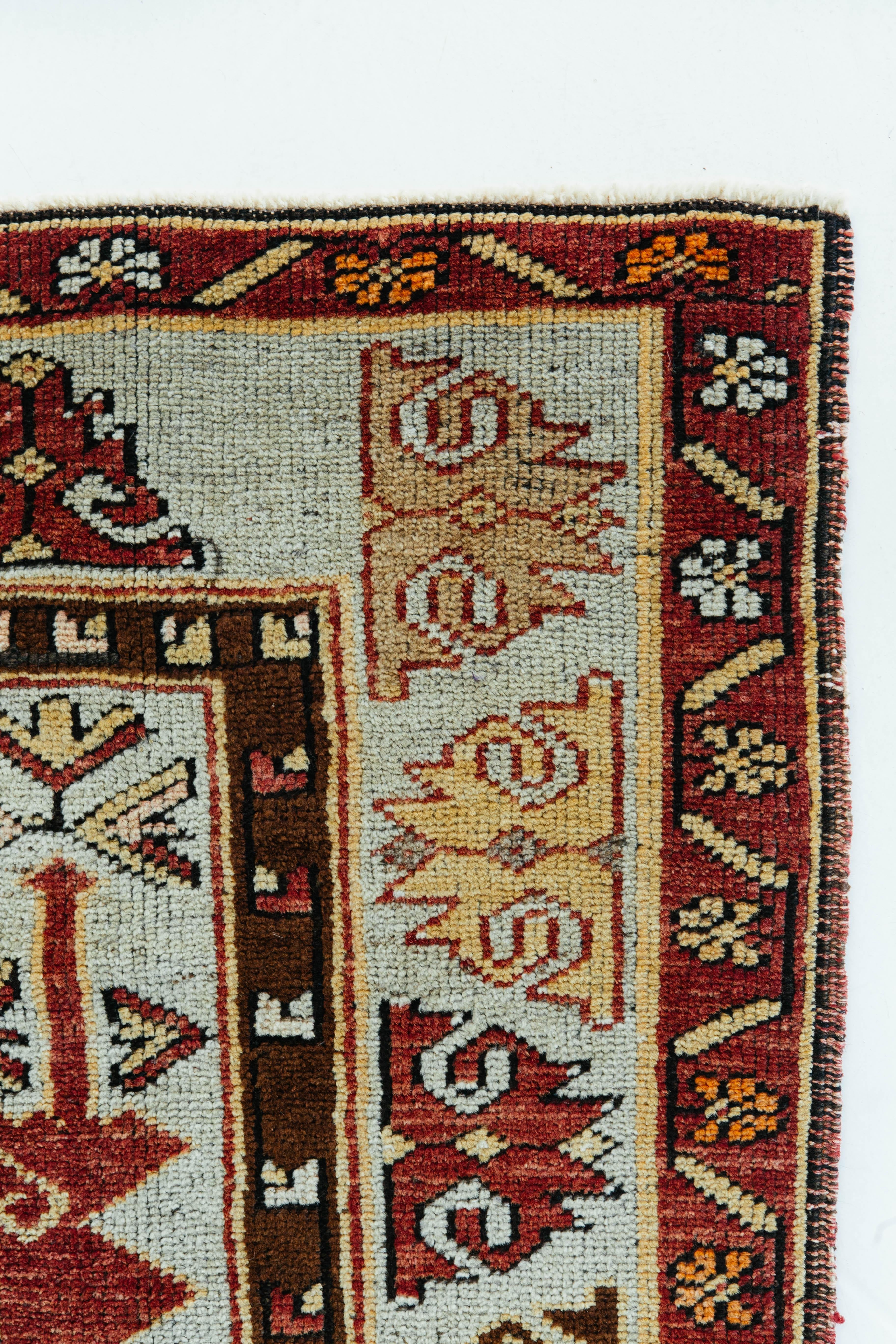 This vintage Turkish Anatolian rug is the perfect tribal rug in cherry red, brown, ivory, and light yellow colors. It consists of traditional Anatolian tribal design including geometric and symmetric patterning of tribal motifs. This rug will bring