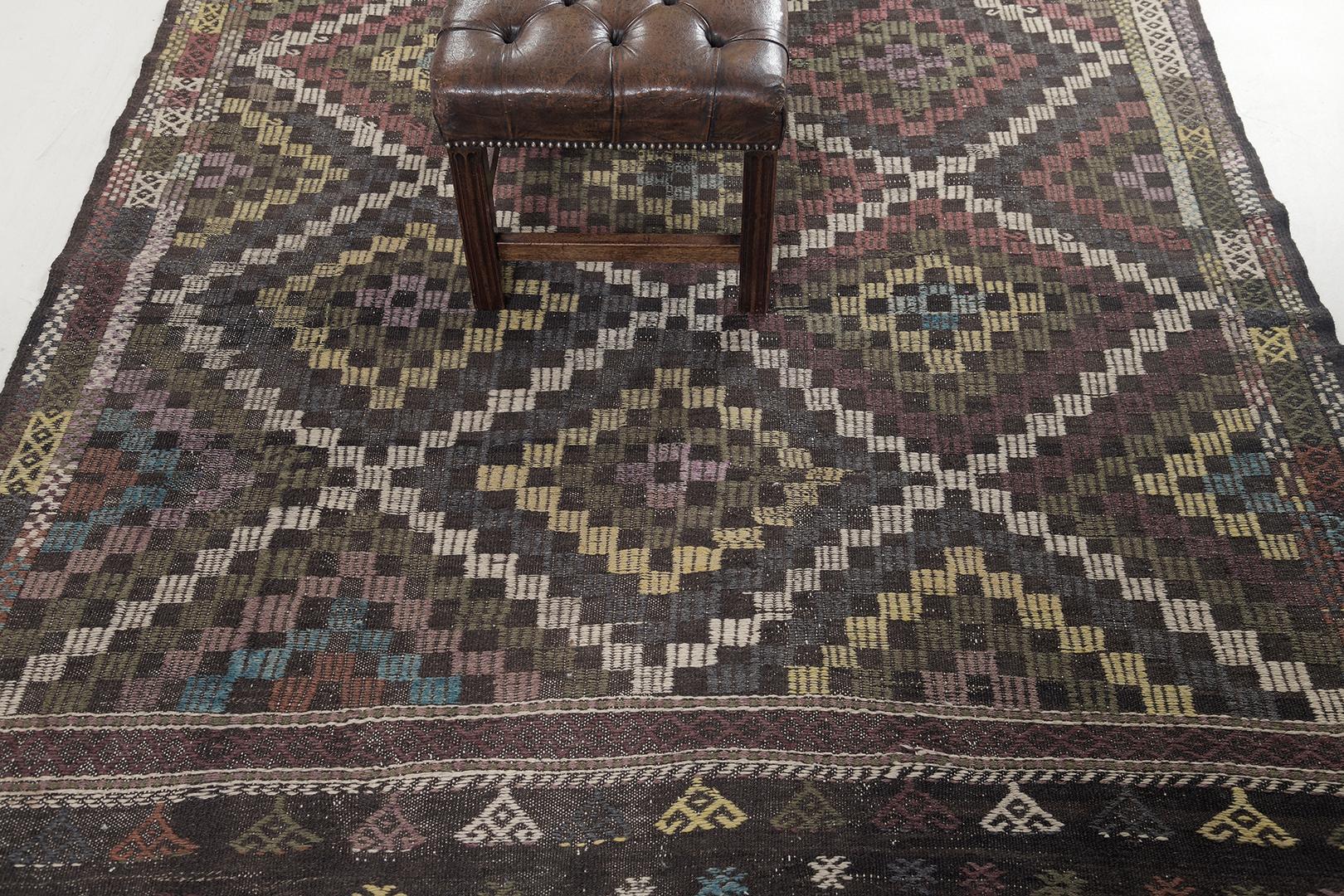 A captivating vintage Turkish Anatolian Jejim Kilim rug featuring an alluring kaleidoscopic effect of stacked lozenges within checkered motifs that gives an interesting and irrisistable feel. Enclosed by Ram’s horn and S symbols bring a distinctive