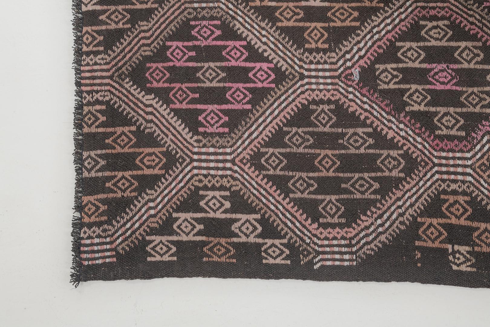 An alluring Vintage Turkish Anatolian Jejim Kilim rug that beguiles you to a panel design pattern of symbolical elements that are poised to amaze. The abrashed light cedar field is covered by eight pointed star’ motifs enclosed in a series of