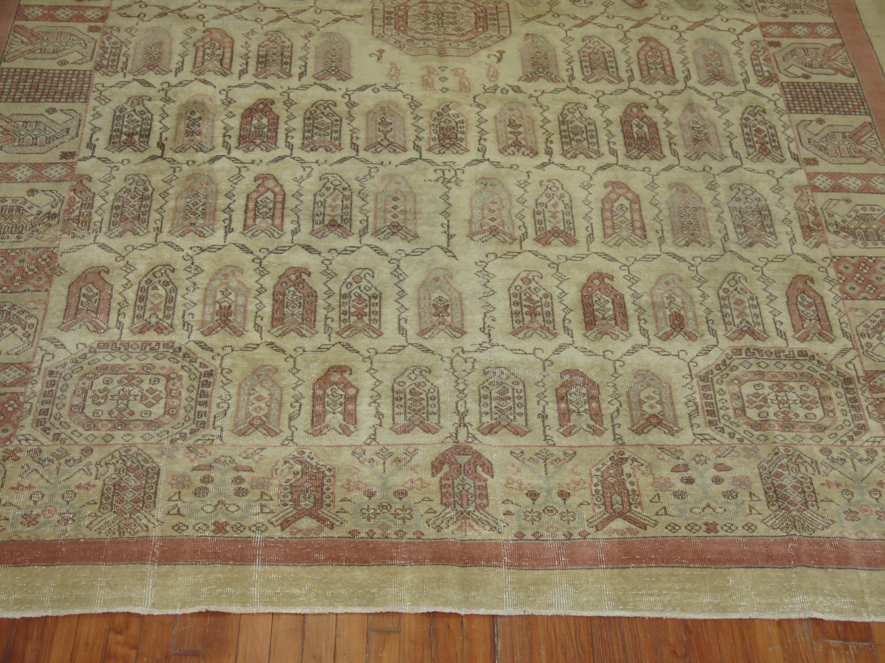 Room size mid-20th century Anatolian rug in crimson red and gray accents on beige/khaki ground.