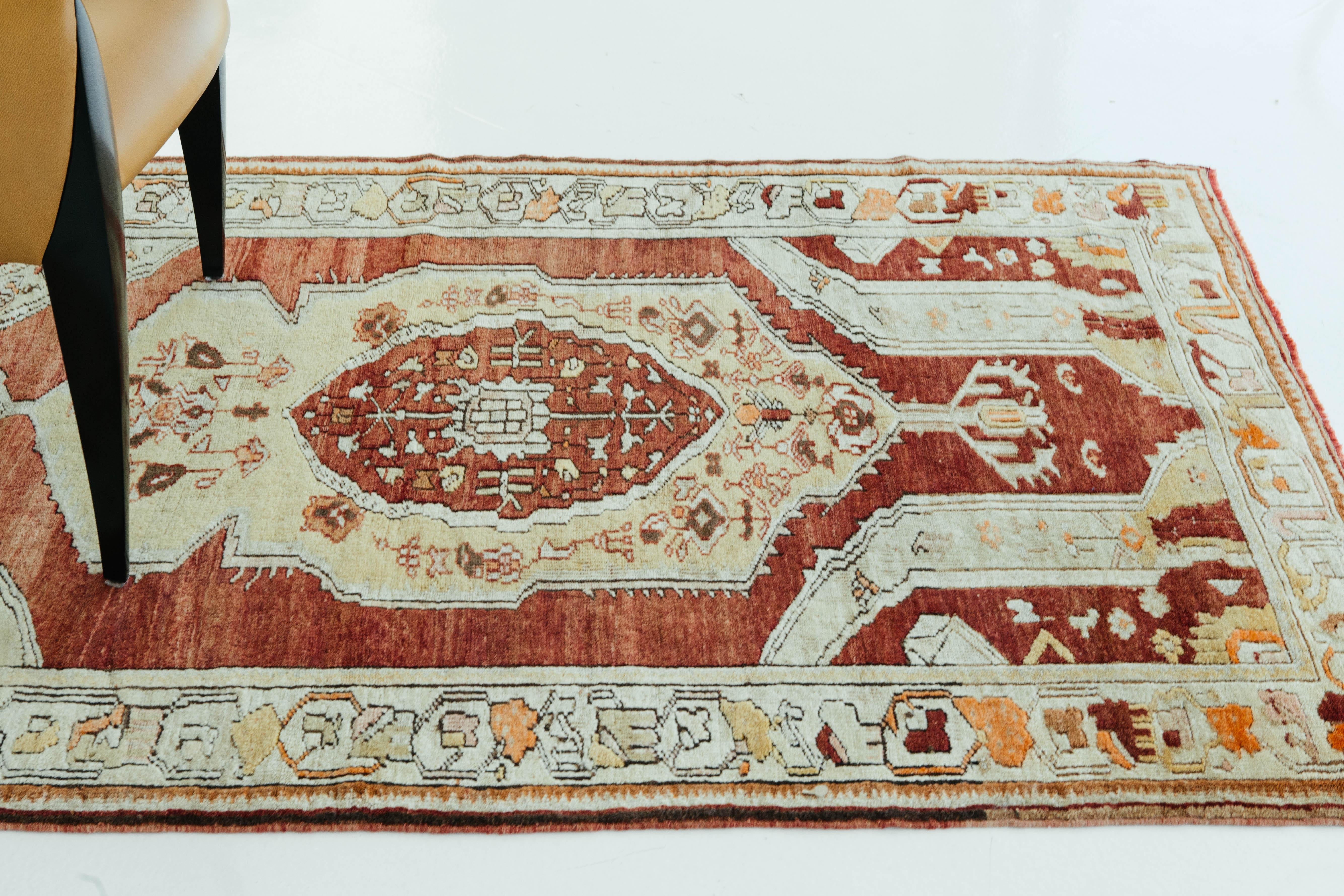 Ruby red, golden yellow, and ivory work cohesively to bring out this Turkish Anatolian rug's elegance. This piece showcases traditional Anatolian designs including the central medallion and the geometric and symmetric patterning of floral motifs.