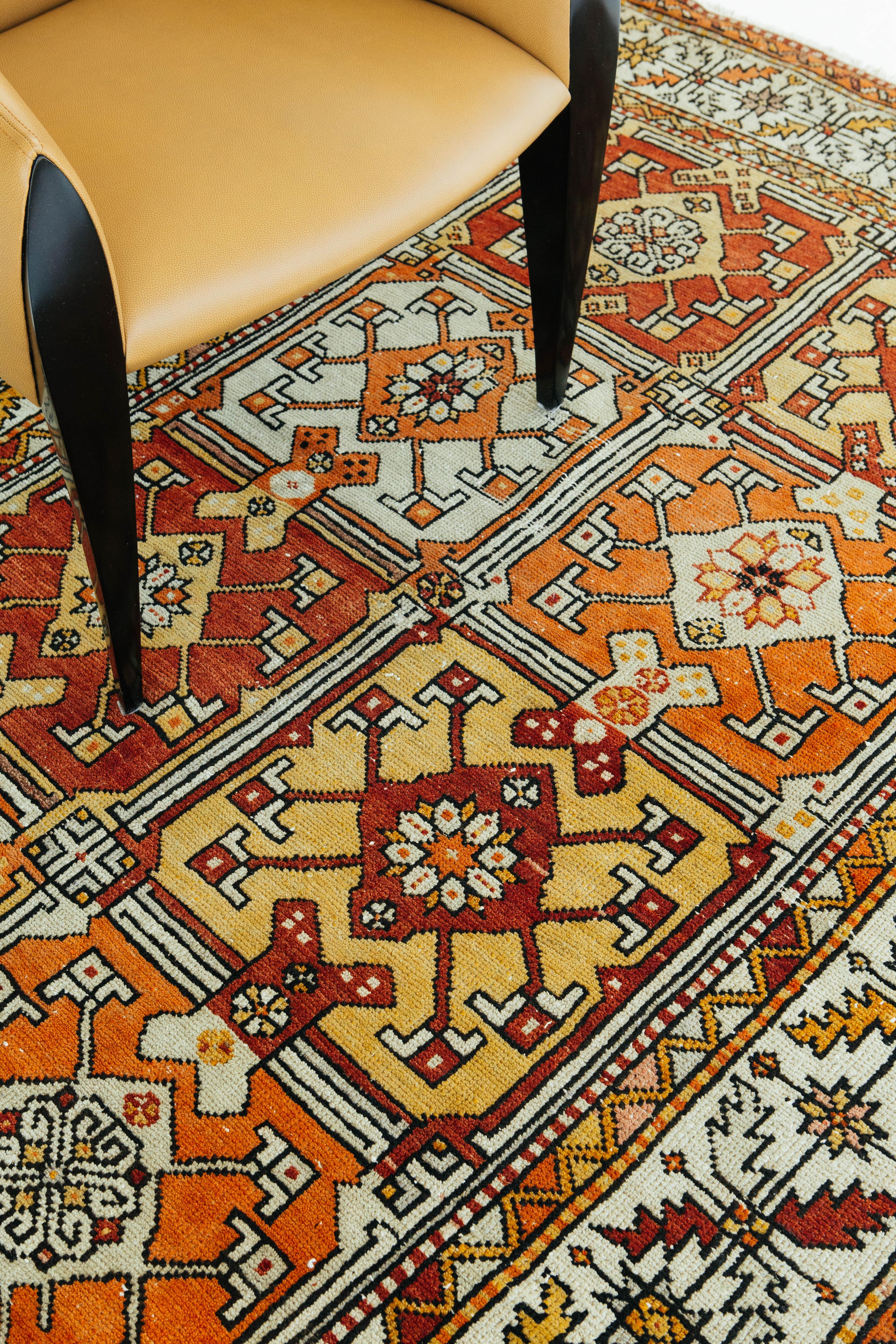 Ein lebendiger und einzigartiger türkischer Teppich aus Anatolien im Vintage-Stil. Tribal-Muster sind in Quadrate eingearbeitet und ebenfalls von lebendigen anatolischen Bordüren umgeben. Türkisch-anatolische Vintage-Teppiche verweben Farbstoffe und