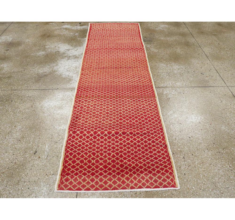 Ein türkisch-anatolischer Vintage-Teppich aus der zweiten Hälfte des 20. Jahrhunderts mit Rautenmuster auf Ziegelgrund.