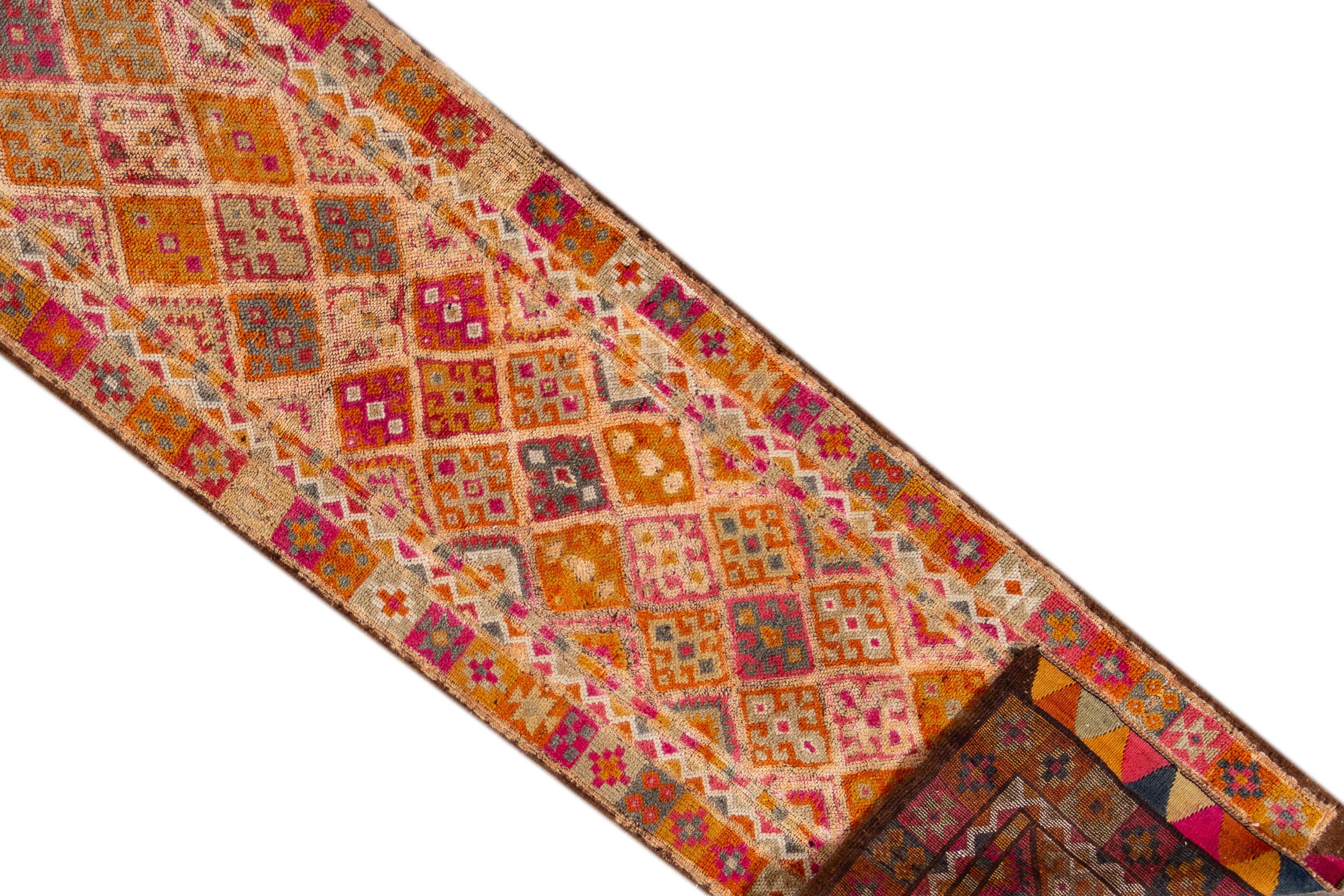 A 20th century vintage Turkish Anatolian runner rug with an all over geometric orange motif. This rug measures at 3'1