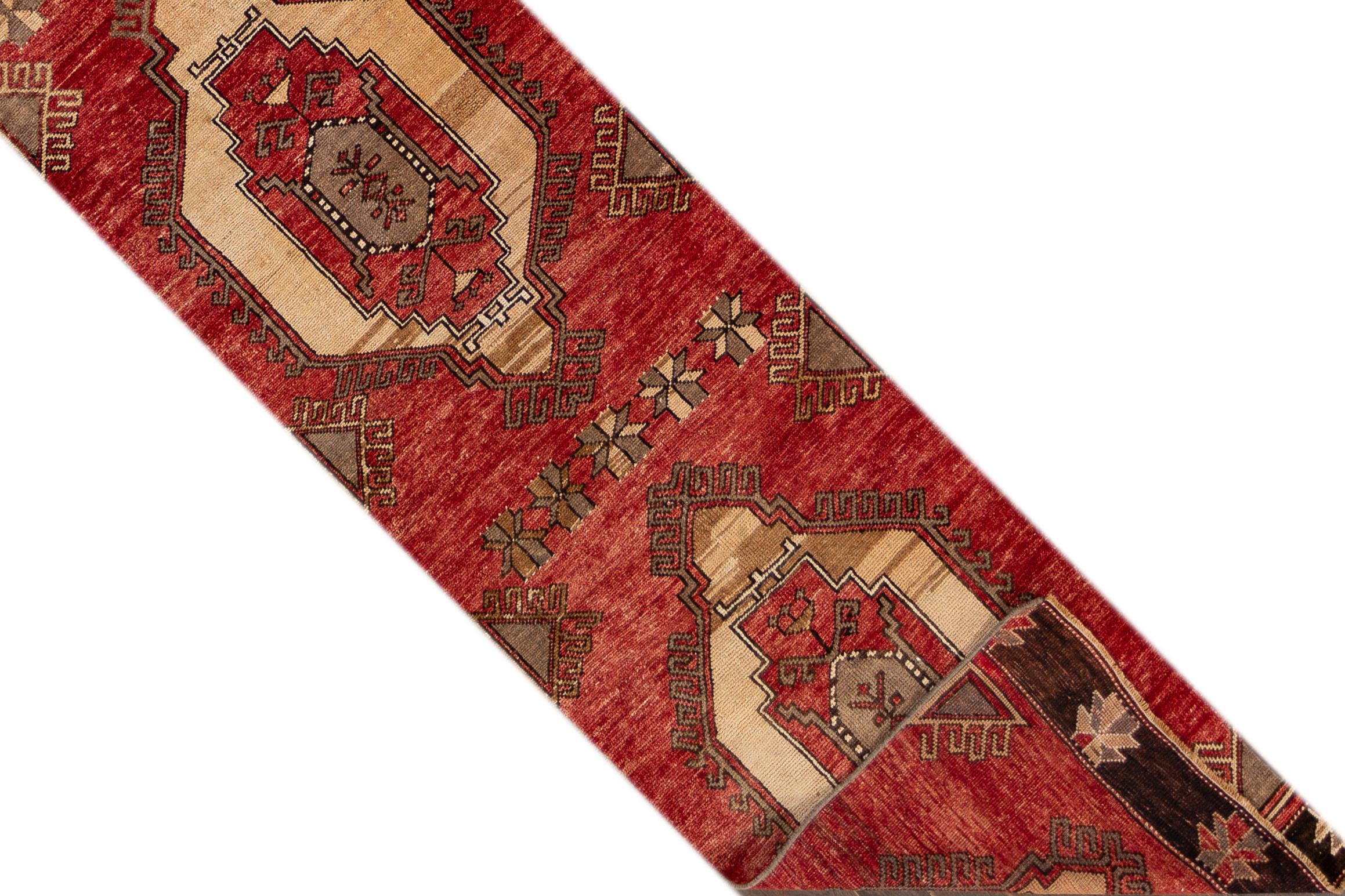 A 20th century vintage Turkish Anatolian runner rug with an all-over red geometric motif. This rug measures at 2'5