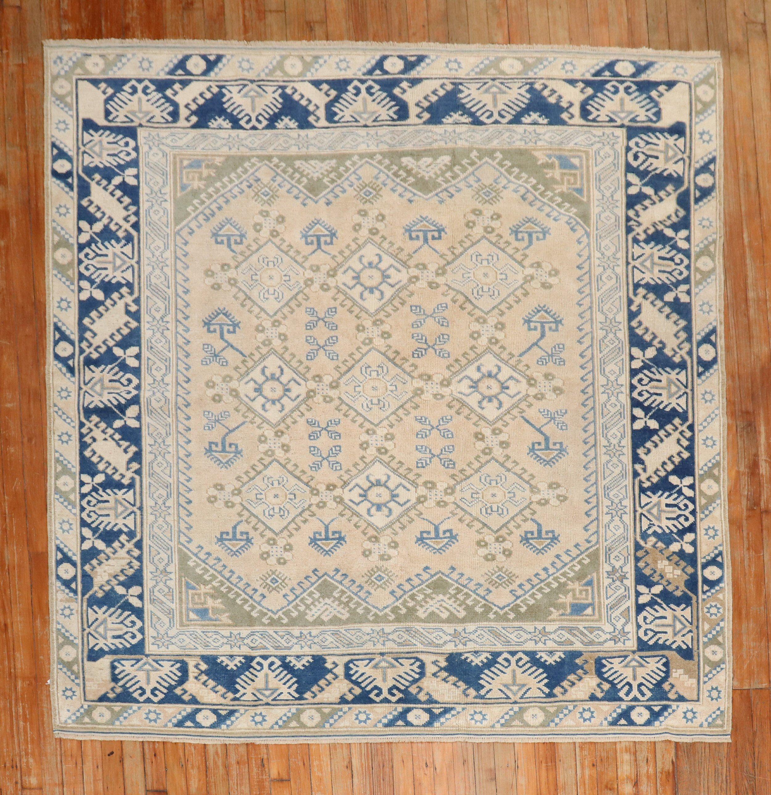 Square size decorative Turkish Anatolian carpet with navy, blue, olive, and brown accents on khaki field

Measures: 6'4'' x 6'6''.