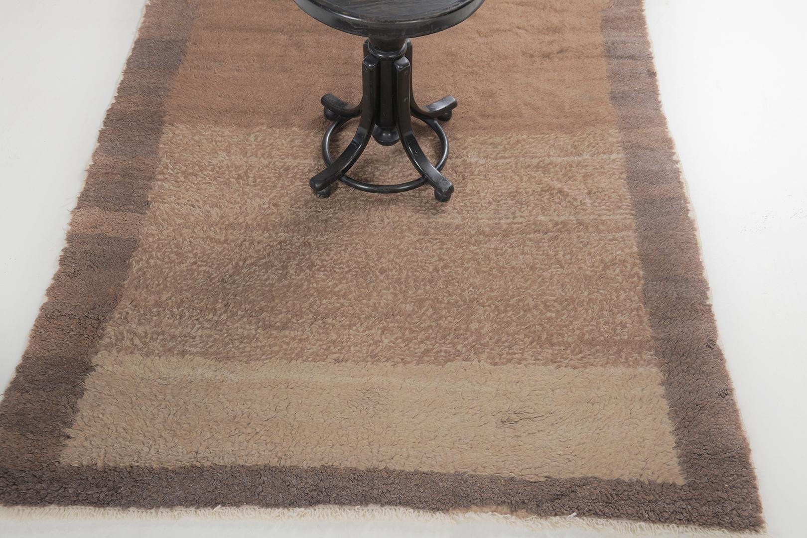 Featuring a gorgeous wool shag of this vintage Turkish Anatolian Tulu that showcases muted and captivating earthy tones of coffee, sand and beige. This mesmerizing rug displays a stunning gradient effect that will soothe your mood after a long day.