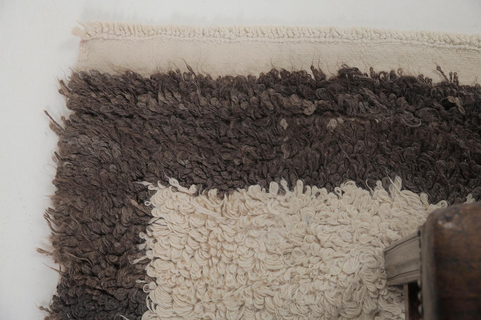 Featuring a gorgeous wool shag of this Vintage Turkish Anatolian Tulu that showcases a muted and captivating earthy tones of ecru and cedar brown. This exquisite rug displays a minimalist effect showcasing its simplicity. Given by this plush