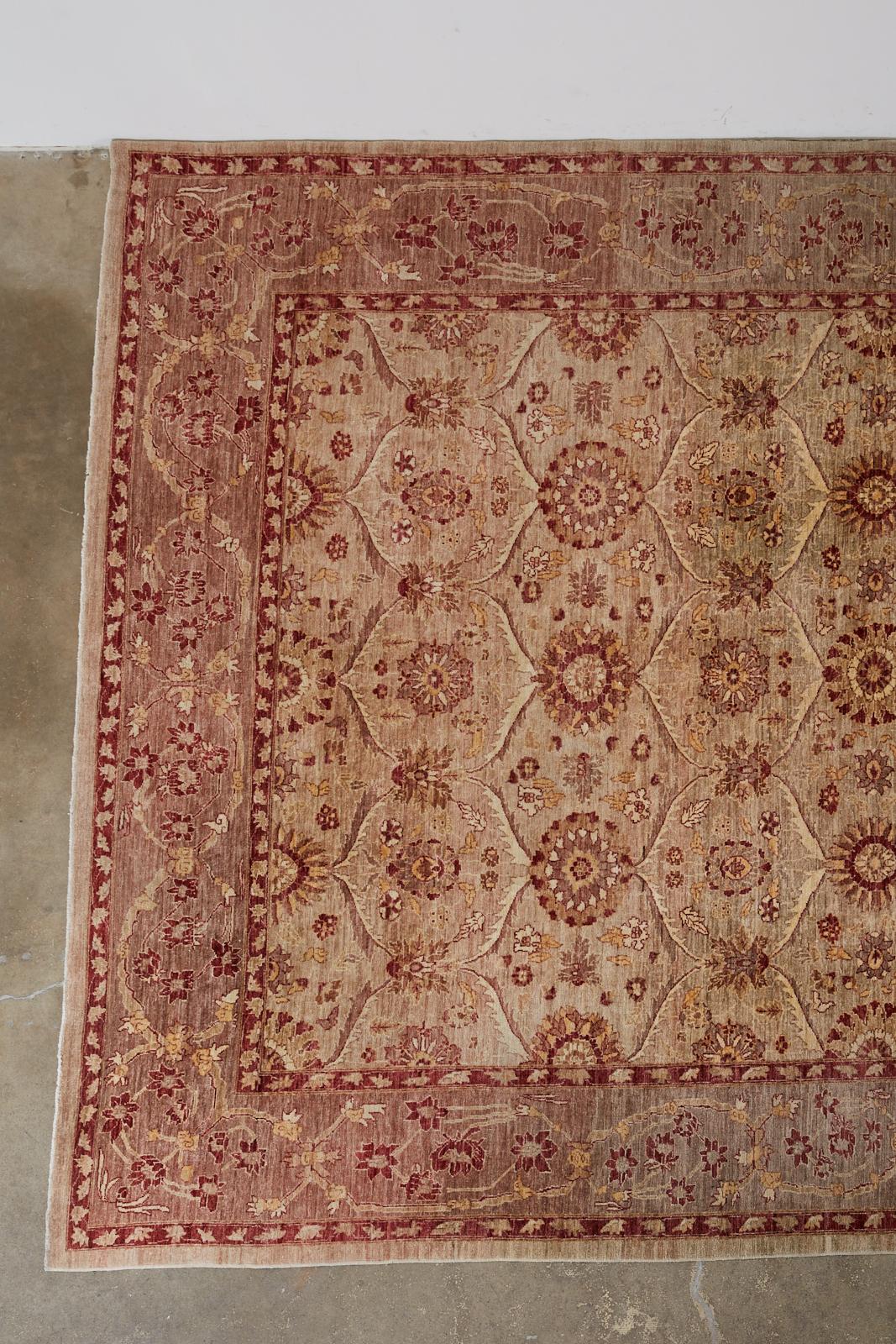 21st Century Turkish Anatolian rug featuring a cranberry color over a beige field. Decorated with stylized flowers made in the Tabriz style from soft handwoven wool. Elegant style with beautiful wear and patina. From an estate in Hollywood, CA.