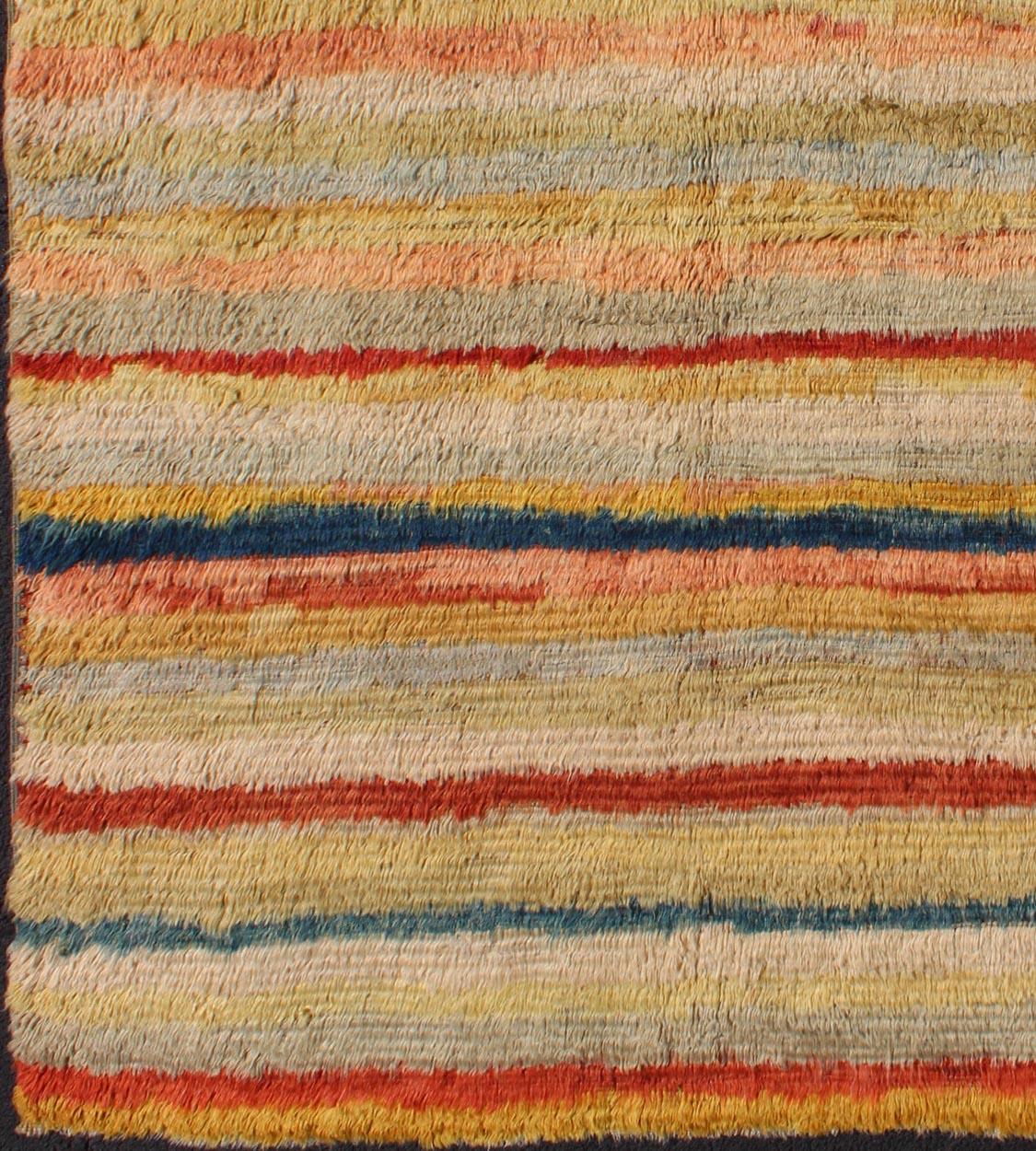 Dieser wunderbare Angora-Tulu-Teppich ist aus feiner Angorawolle in einer weichen und farbenfrohen Palette handgewebt und weist ein Streifenmuster in kräftigen und gedeckten Tönen auf. Die einzigartige Textur und die ungewöhnlichen Muster der