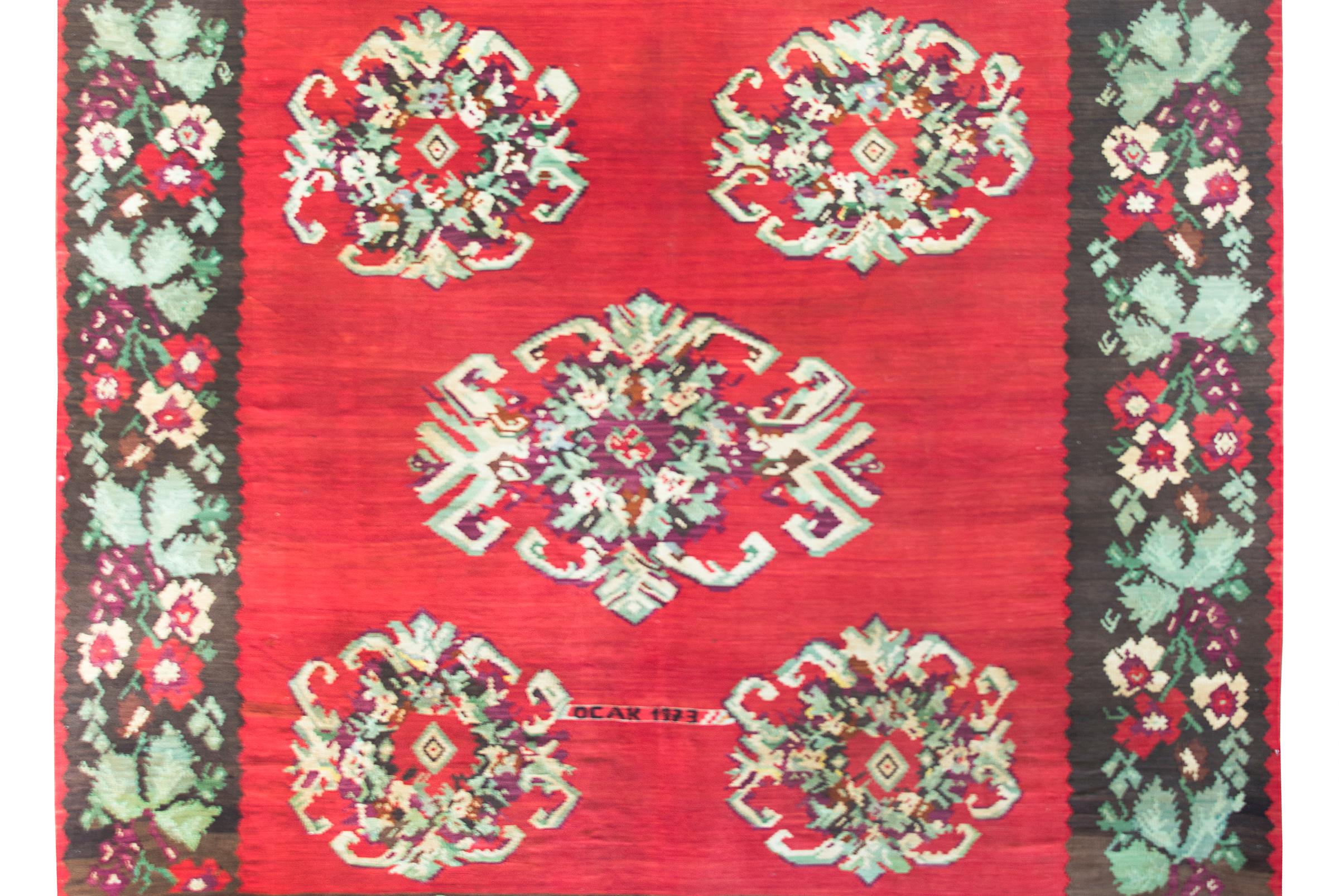 A fantastic vintage Turkish Bessarabian Kilim rug with the most wonderful large-scale stylized floral medallions living against a crimsons field, surrounded by more large-scale flowers on the border, and all woven in crimson, green, white, and