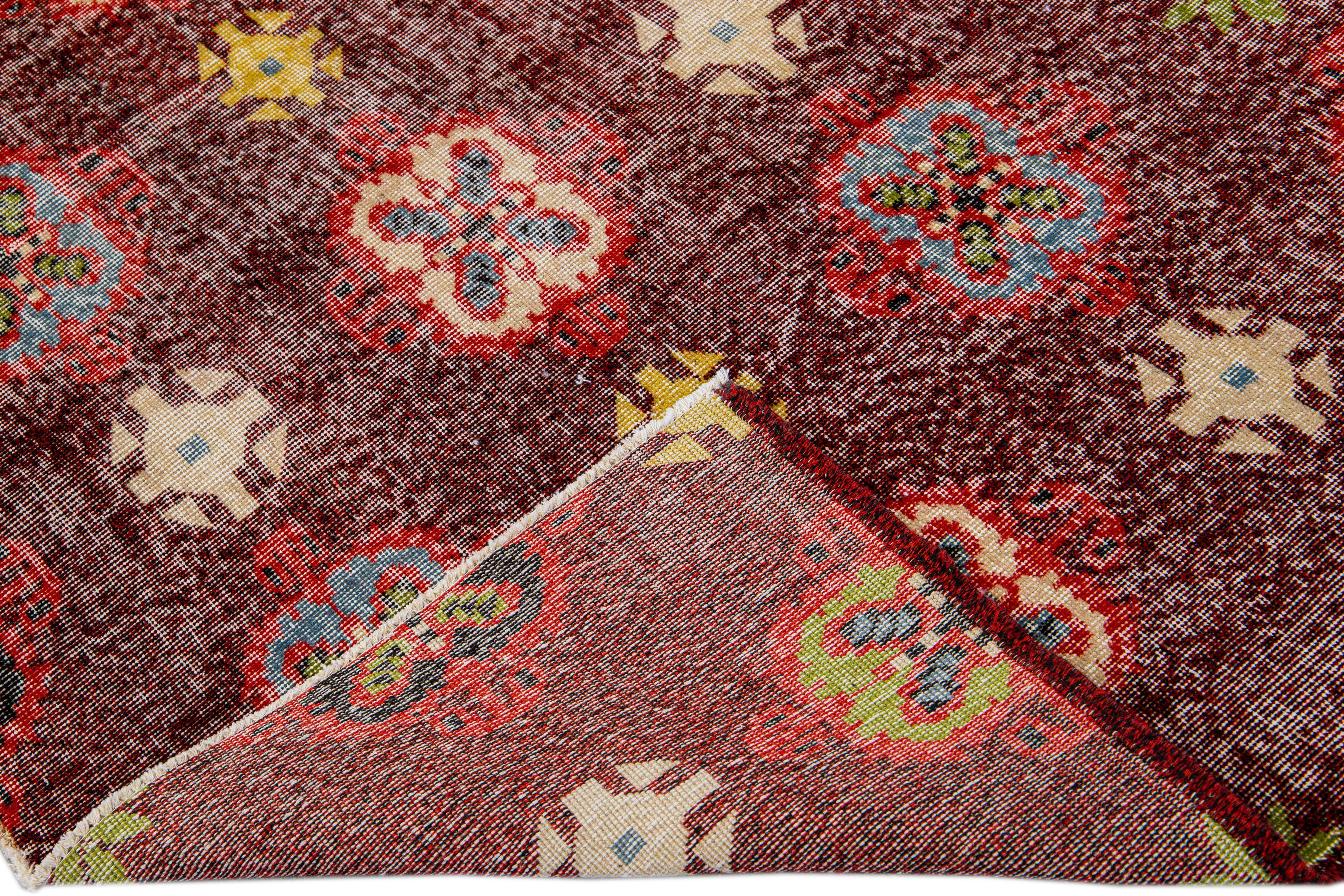 Beautiful vintage Deco Turkish hand-knotted wool rug with a burgundy field. This Turkish rug has red, blue, yellow, and beige accents in a gorgeous all-over floral pattern design.

This rug measures: 5'7