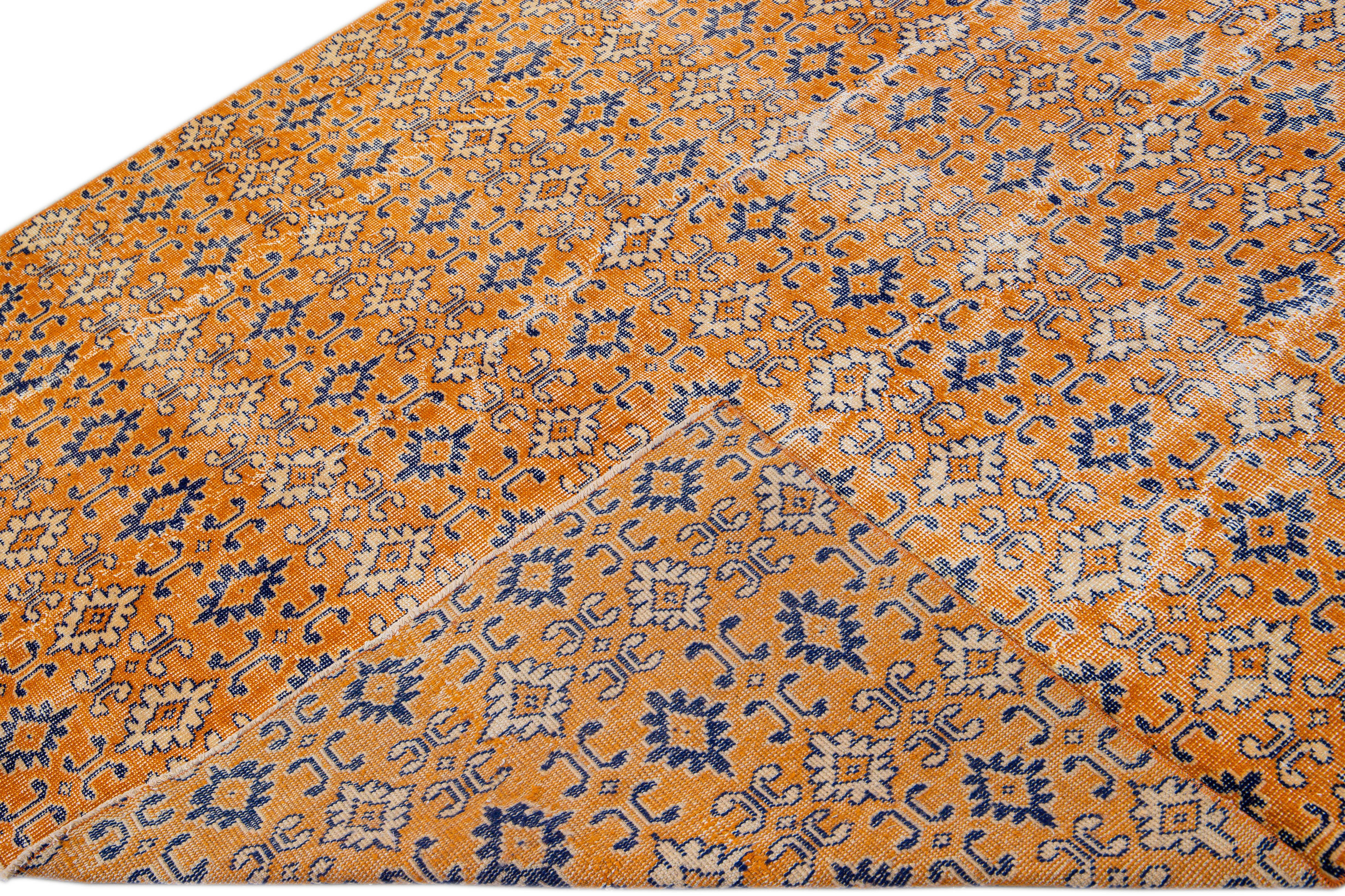 Beautiful vintage Deco Turkish hand-knotted wool rug with an orange field. This Turkish rug has blue and peach accents in a gorgeous all-over geometric floral pattern design.

This rug measures: 6'6