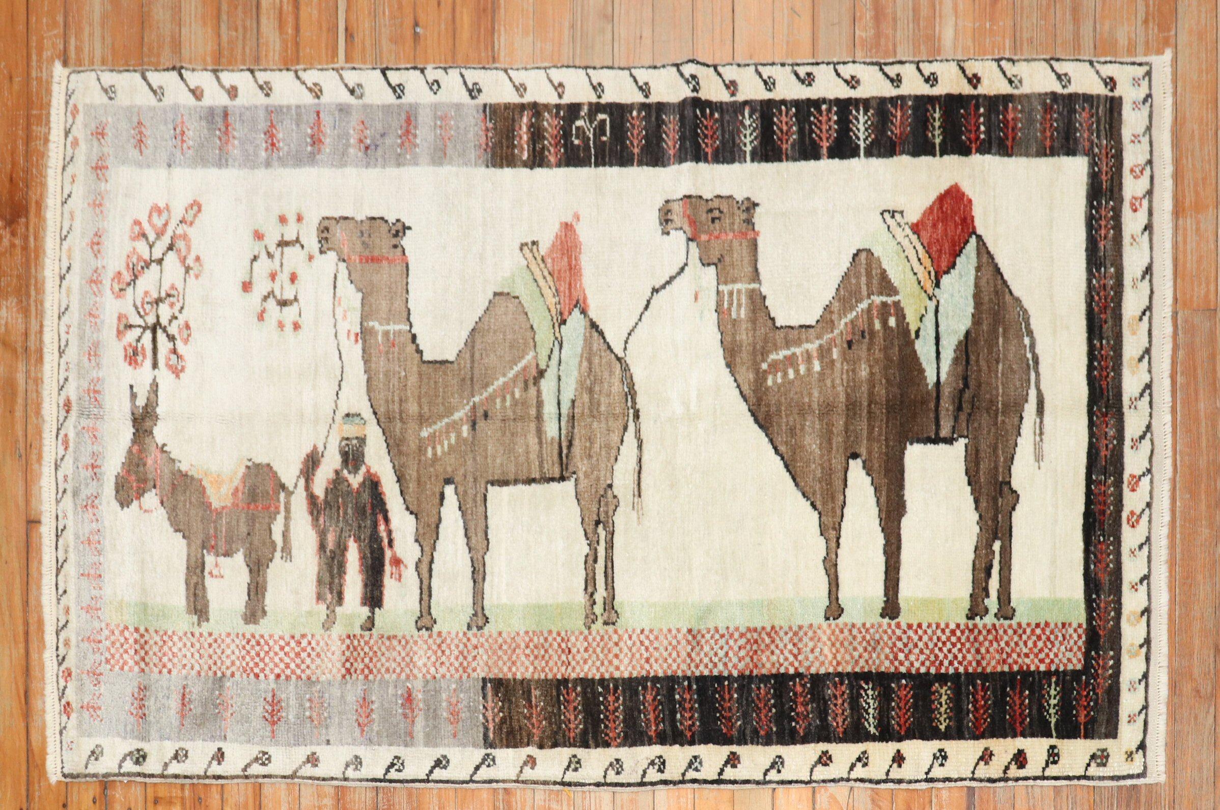 Mid 20th century colrufl Turkish rug depicting camel and donkeys on an ivory ground. The striation of colors on 1 end is referred to as abrash which is natural color variations found in some vintage and antique rugs from the 20th century

Size: