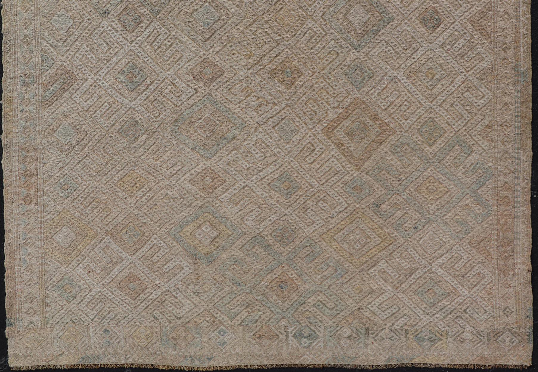 Measures: 5'0 x 6'5

This vintage Turkish Kilim features soft neutral colors and a woven texture. The design is a sub-geometric tribal diamond design in faded light green, tan, taupe, and cream. The border has a repeating tribal design. 

Country of