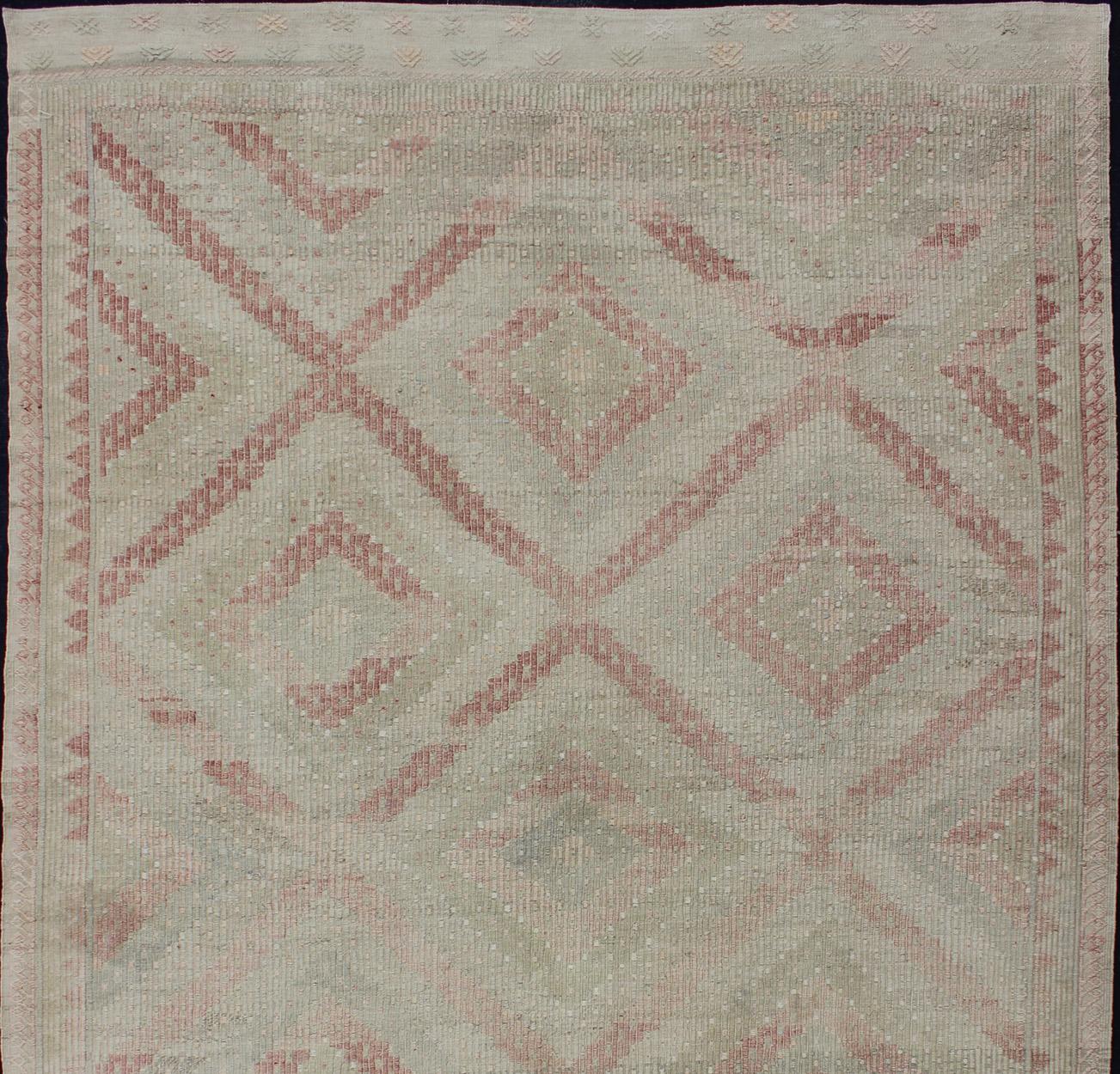 Large Embroidered vintage rug from Turkey in shades of tan, light green, light red, and cream with geometric pattern, rug EN-179324, country of origin / type: Turkey / Kilim, circa 1950.

This geometric embroidered flat weave from Turkey bears a