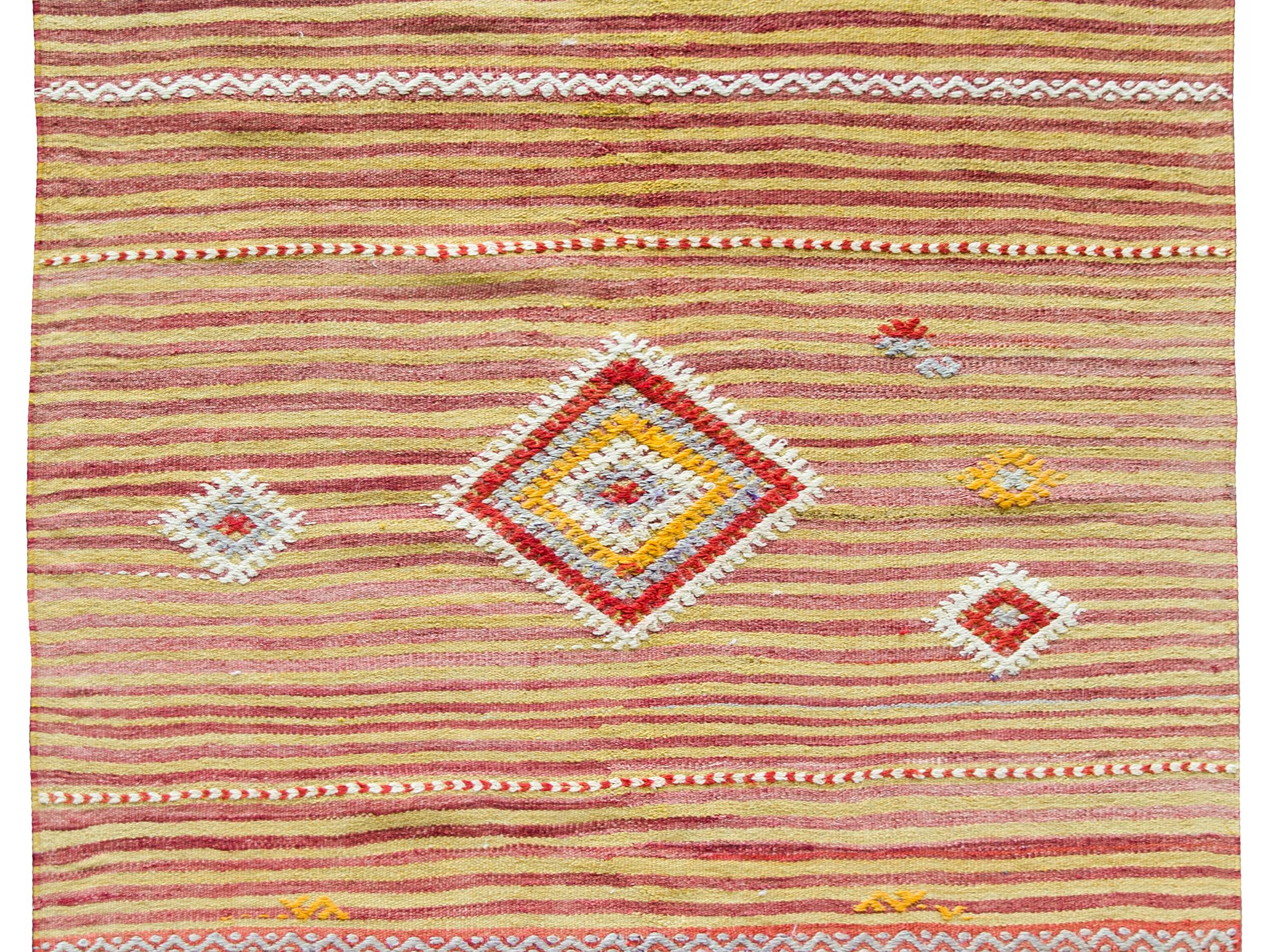 A wonderful vintage Turkish Kilim rug with a beautiful multi-colored stripe pattern with several diamond patterns asymmetrical embroidered into the field.